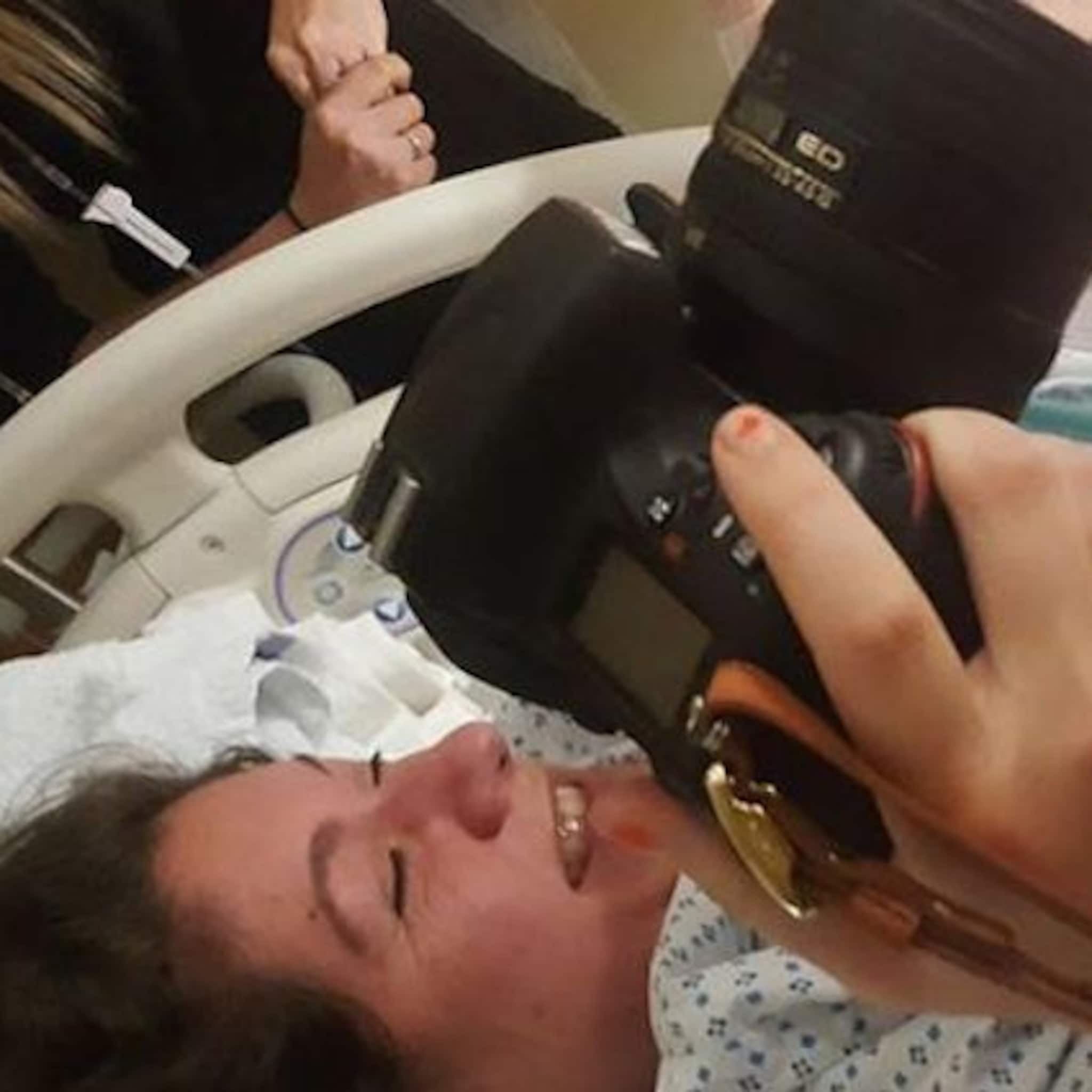 vrouw haalt spiegelreflexcamera tevoorschijn tijdens eigen bevalling