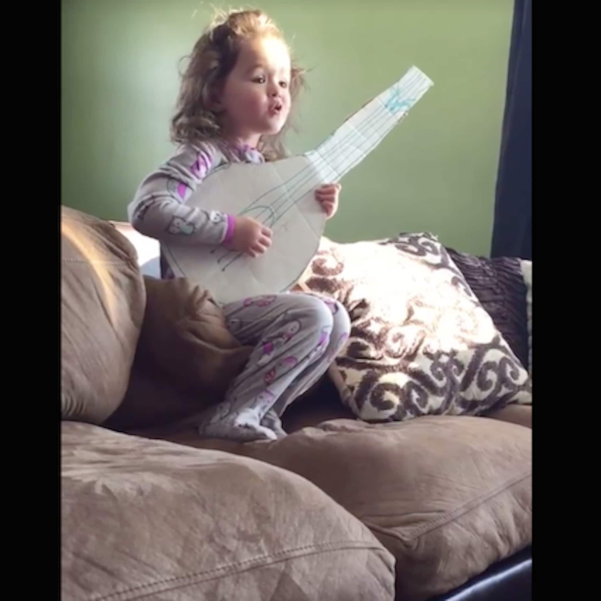 schattig meisje zingt hello op zelfgeknutselde gitaar