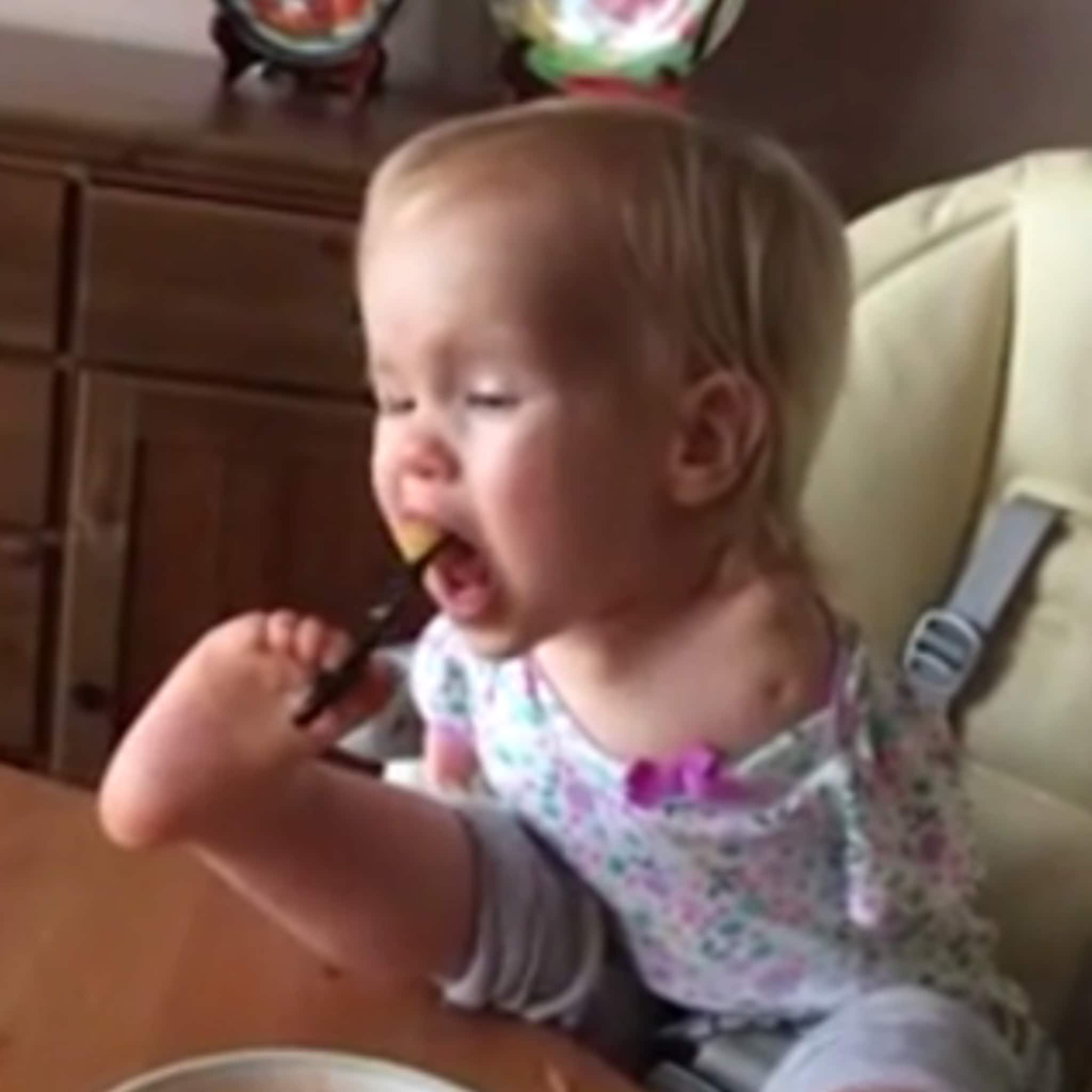 inspirerend meisje zonder armen leert zichzelf eten met haar voeten