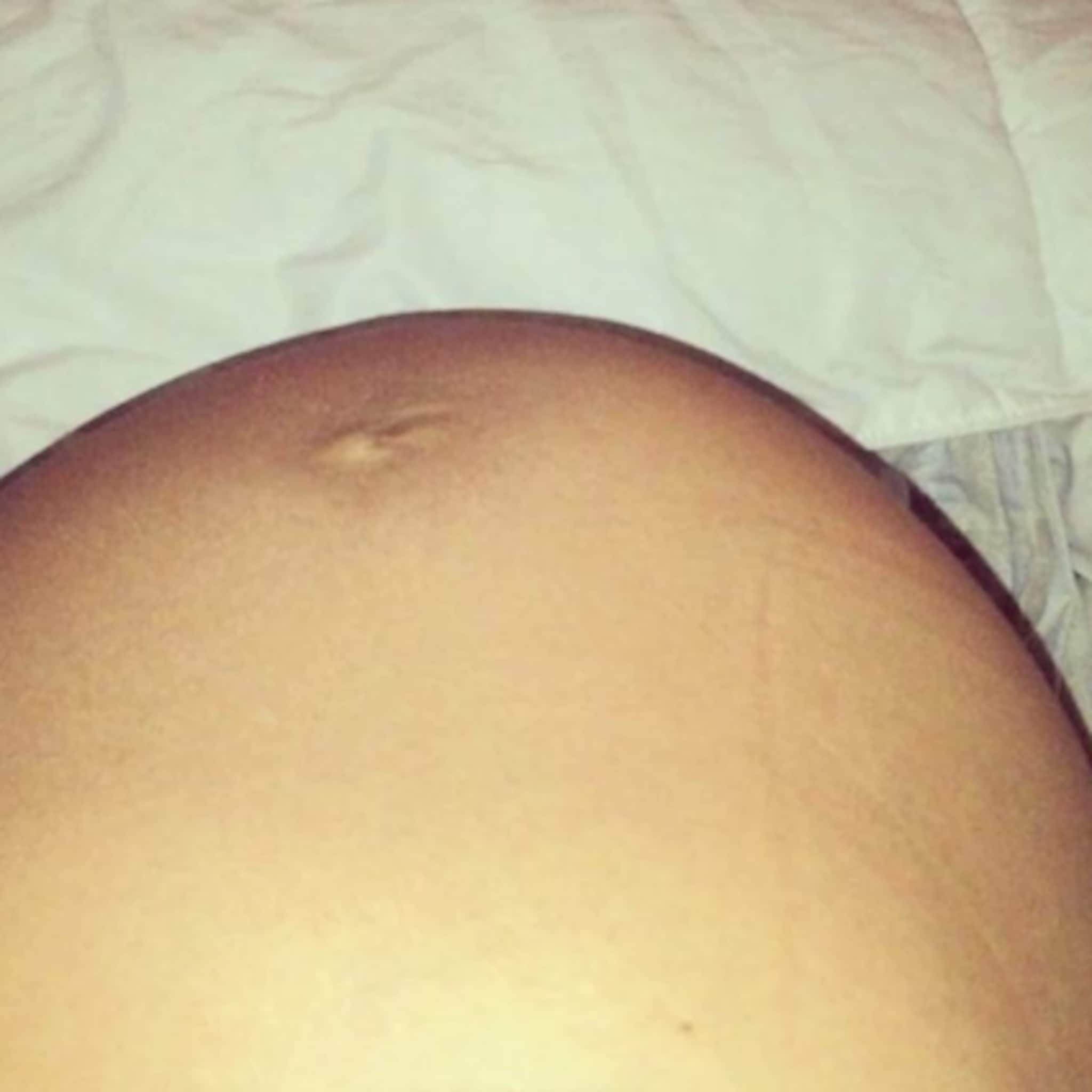 zwangere vrouw legt koprol van baby in buik vast op camera