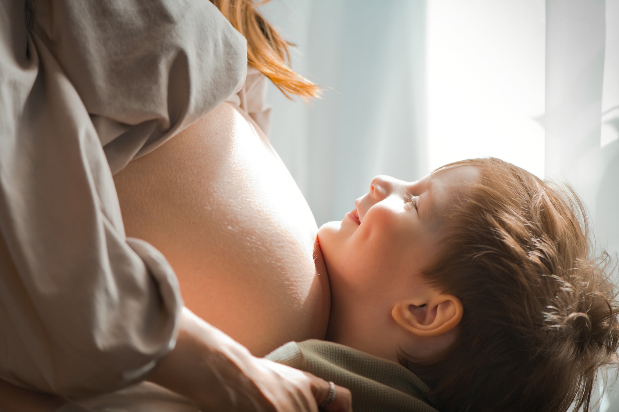 Cute little boy and his pregnant mother indoors Getty Images