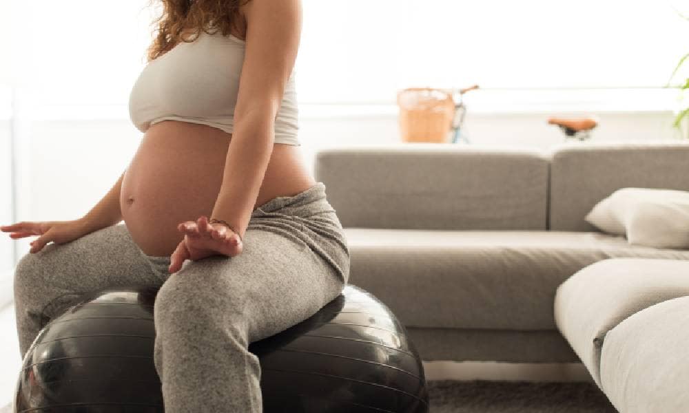Zwangere vrouw zittend op bevalbal Getty Images