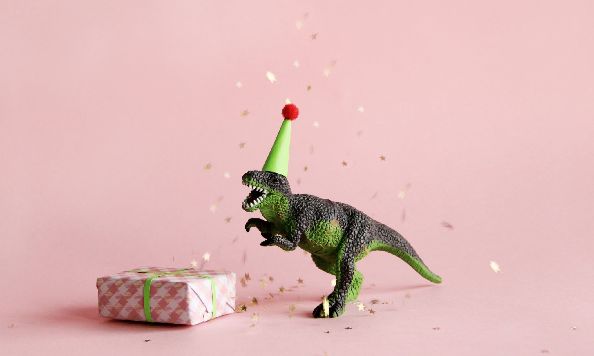 Dinosaurus met feesthoedje en cadeautje - De leukste cadeautips voor kinderen van twee jaar Getty Images