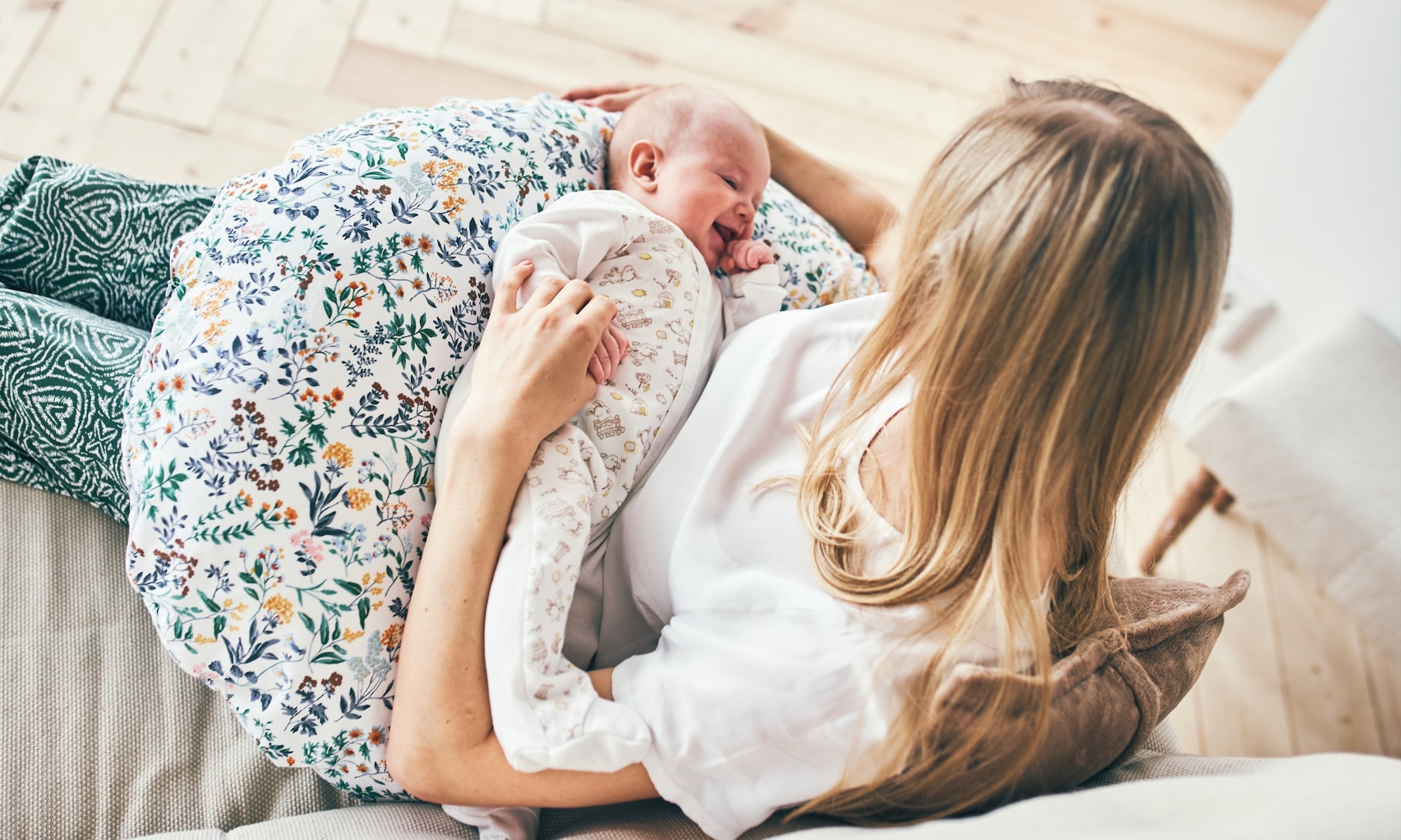 Moeder en baby samen met comfortabel voedingskussen of zwangerschapskussen Getty Images