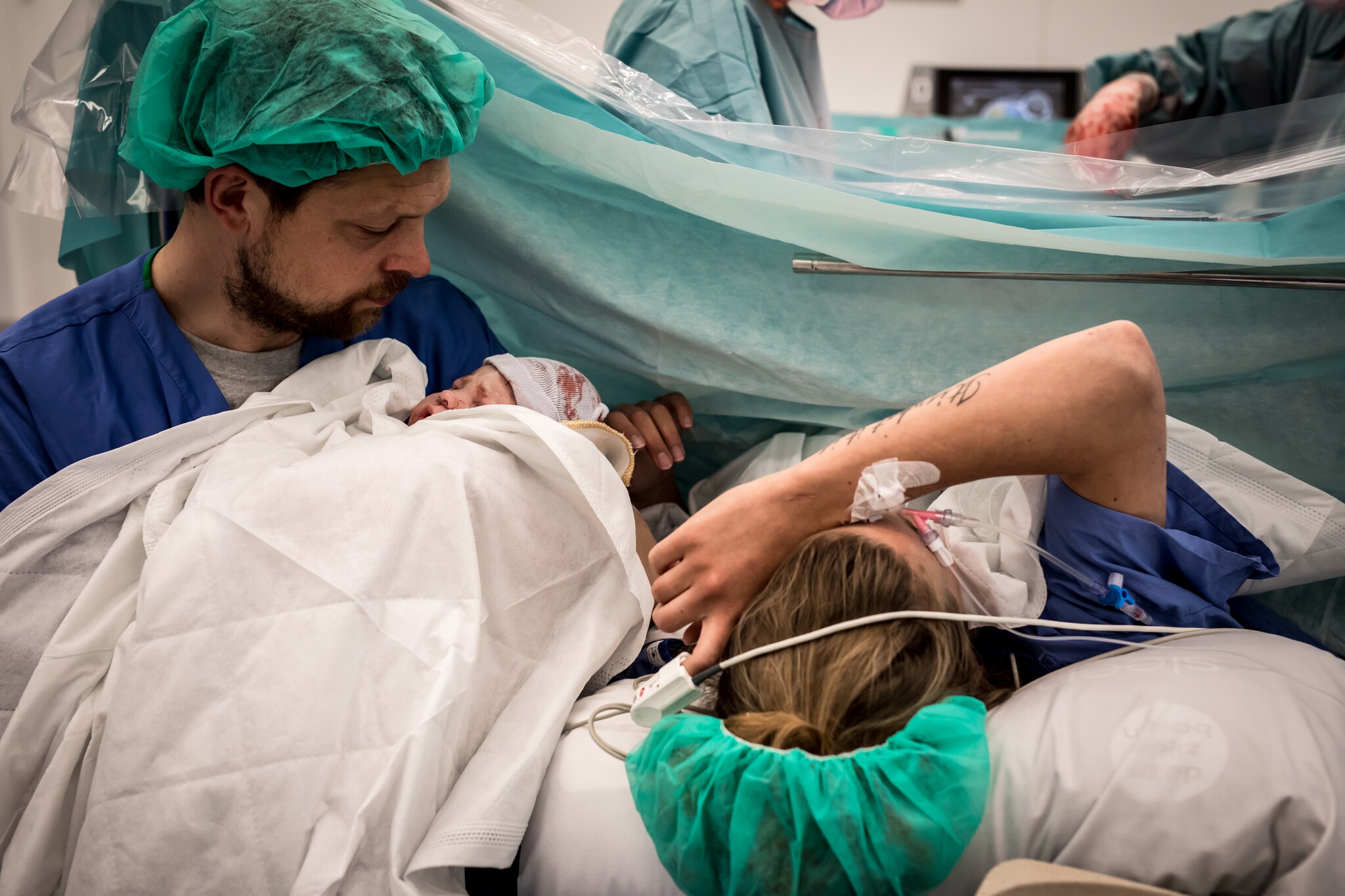 Saskia Toonen, haar partner Laurens Weers en hun net geboren zoontje Benjamin vlak na de keizersnede. fotograaf: Mirjam Cremer, Pure Life Geboortefotografie
