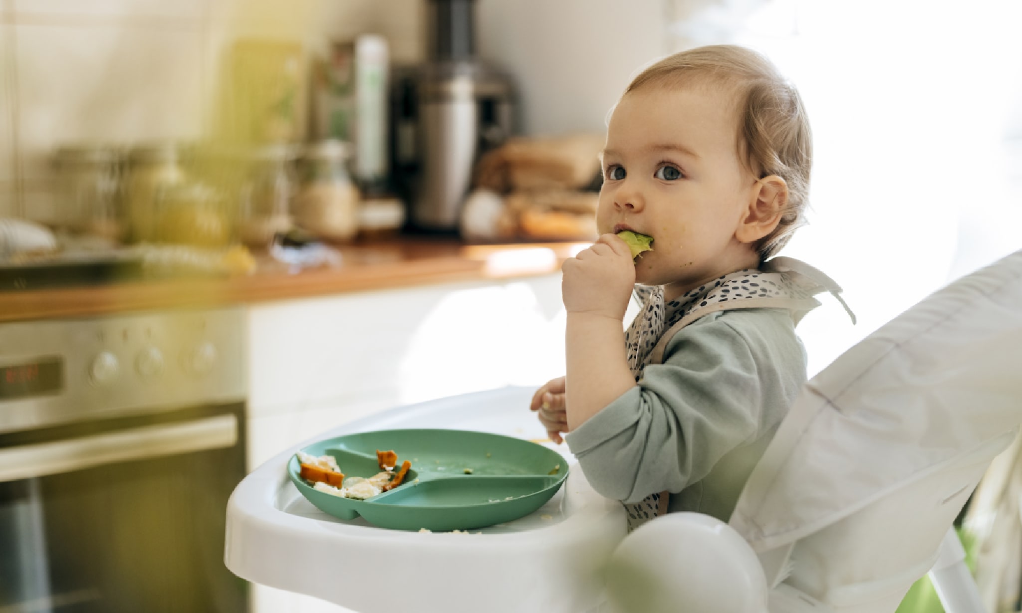 Je handen vrij op vakantie: van wipper tot inklapbare kinderstoel - baby zit in kinderstoel en eet Getty Images