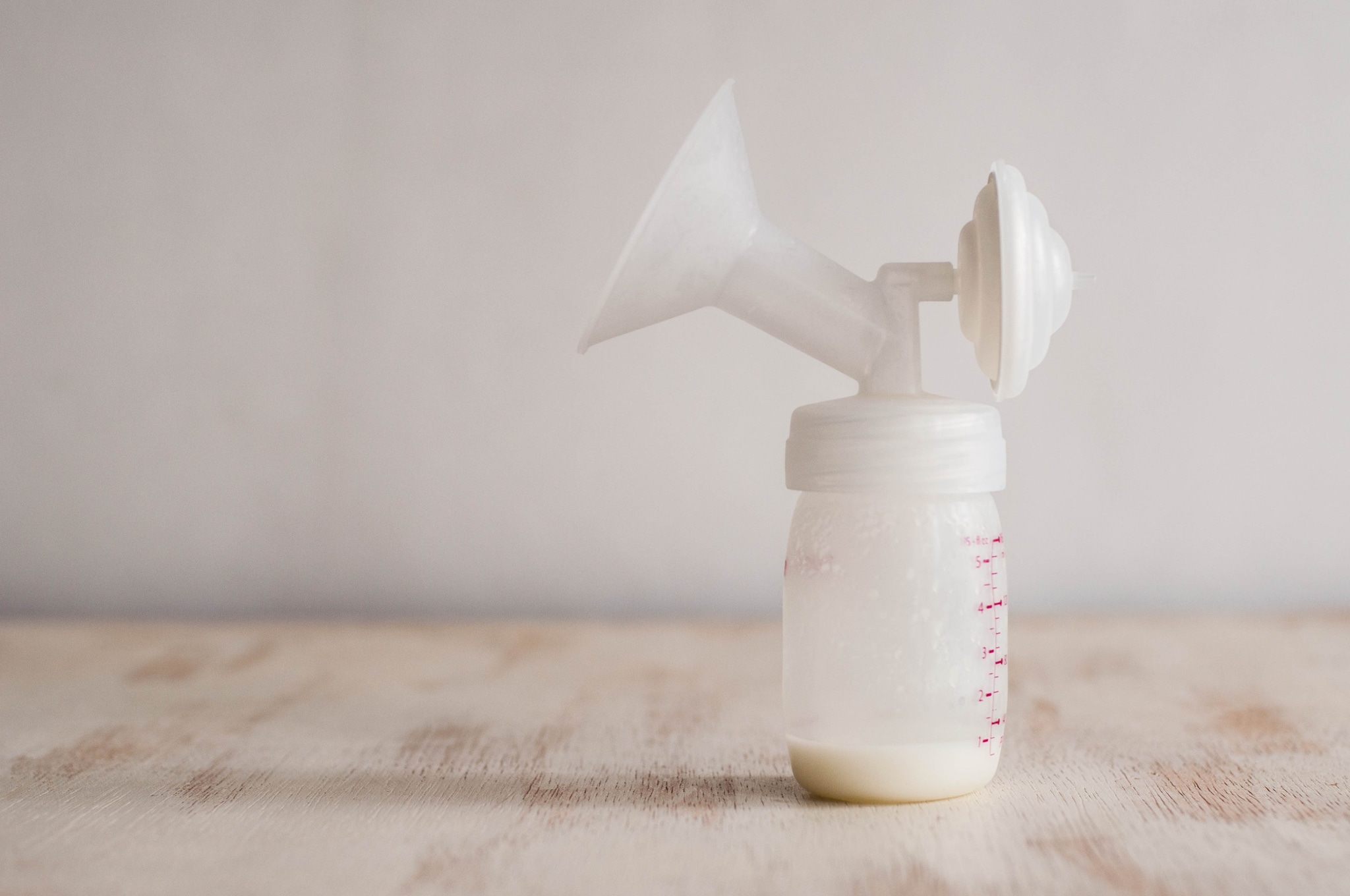 Still life of fresh breast milk in the breast pump milk container on a white background Getty Images