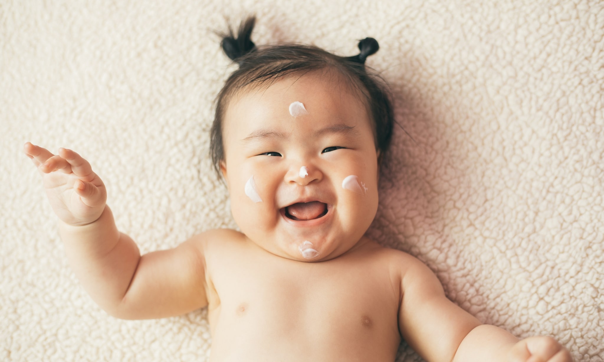 baby wordt ingesmeerd met veilige babyverzorgingsproducten Getty Images