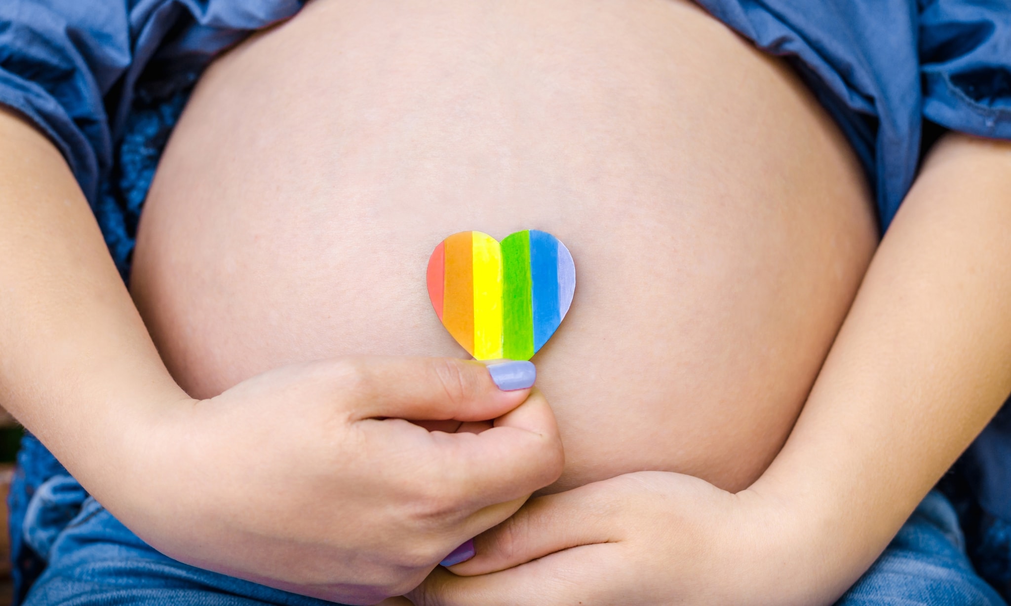 Zwangere vrouw met regenboogsymbool, bij artikel over draagmoederschap Getty Images