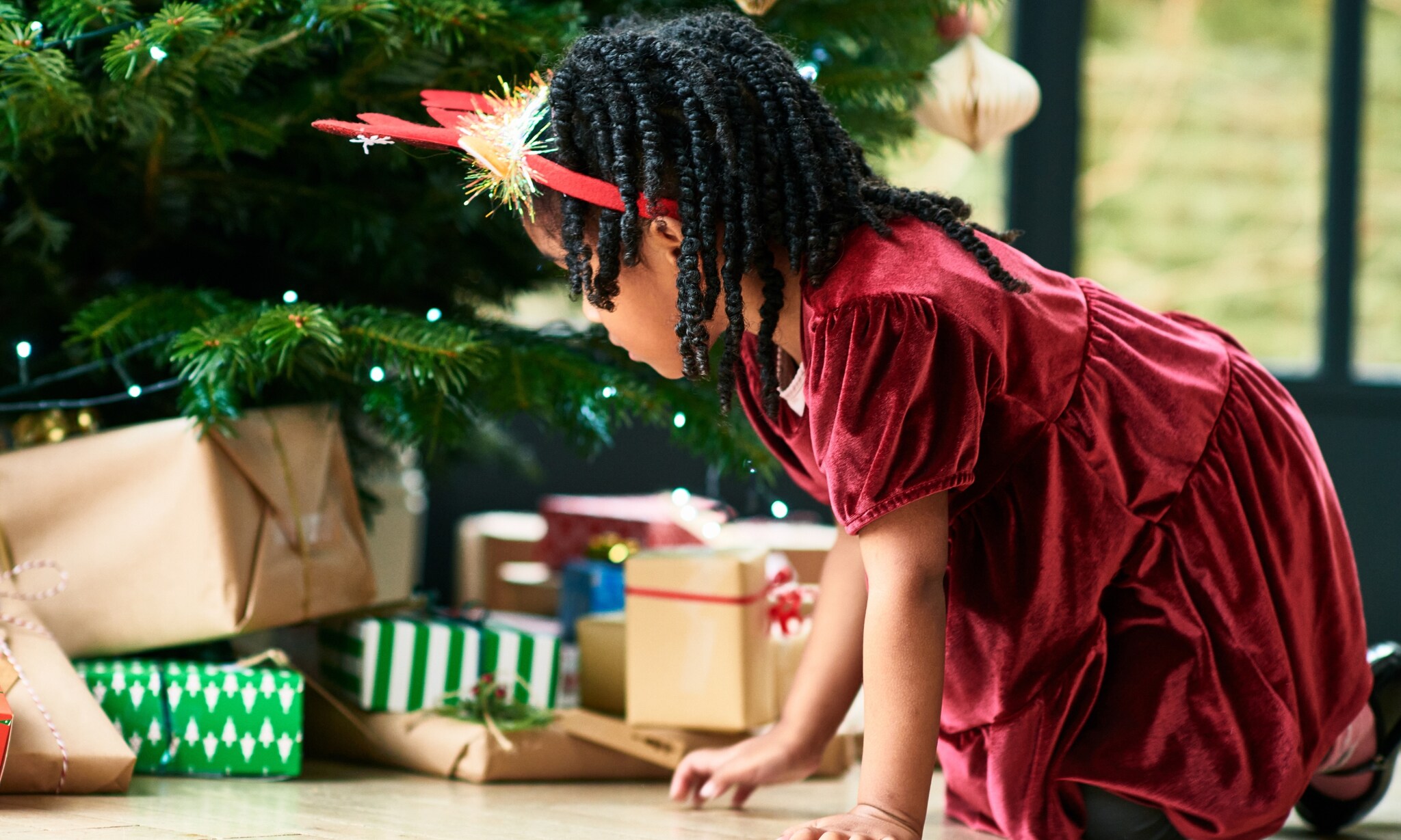 kind draagt rode fluwelen jurk, een van de kerstoutfits voor jongens en meisjes Getty Images