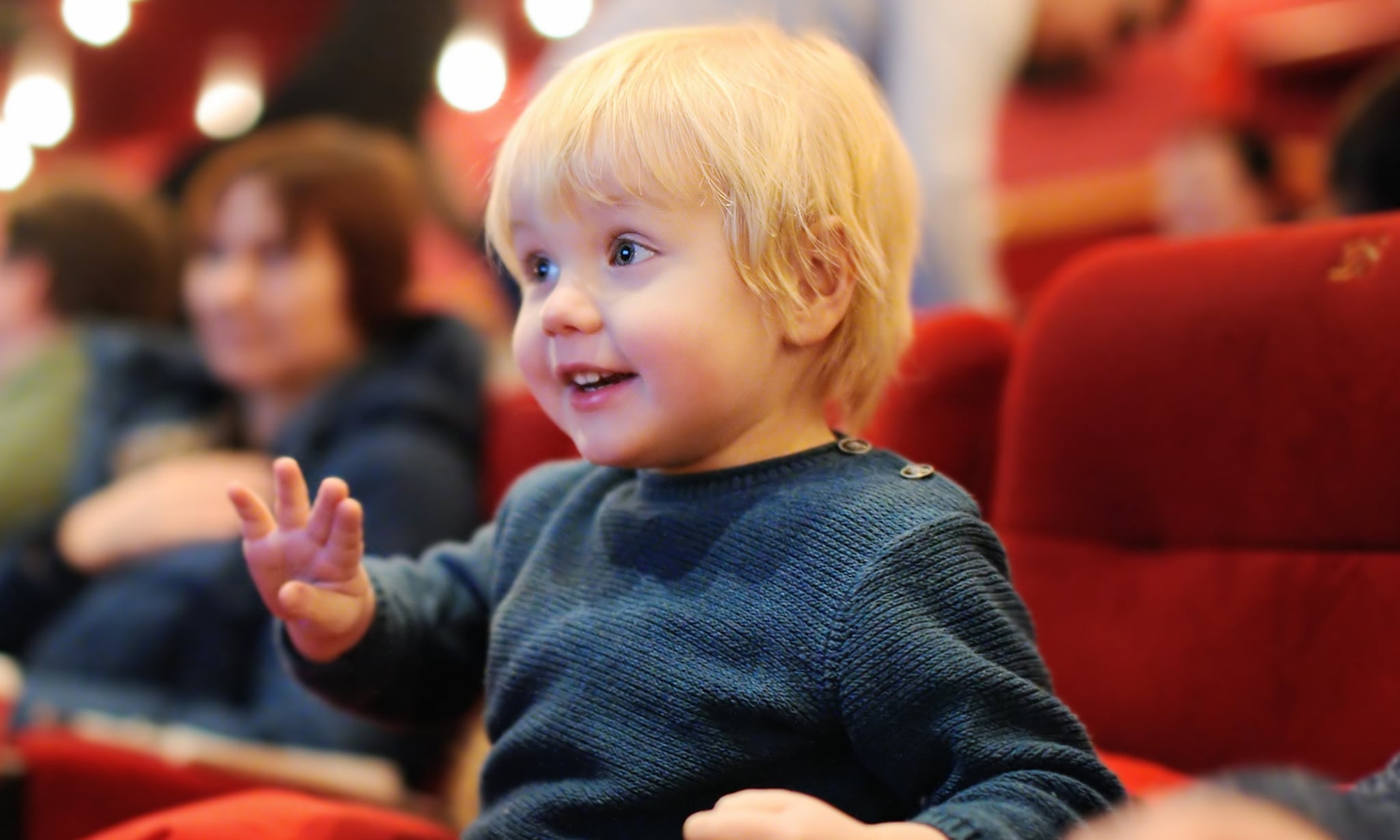 Dreumes of peuter kijkt in het theater naar een voorstelling voor kinderen Getty Images