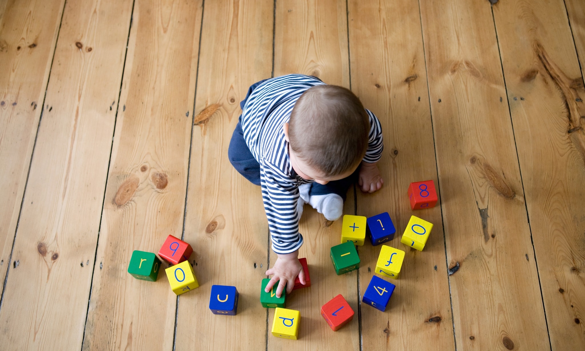 Baby speelt met blokken waar letters op staan, bij artikel over babynamen en trends. Getty Images