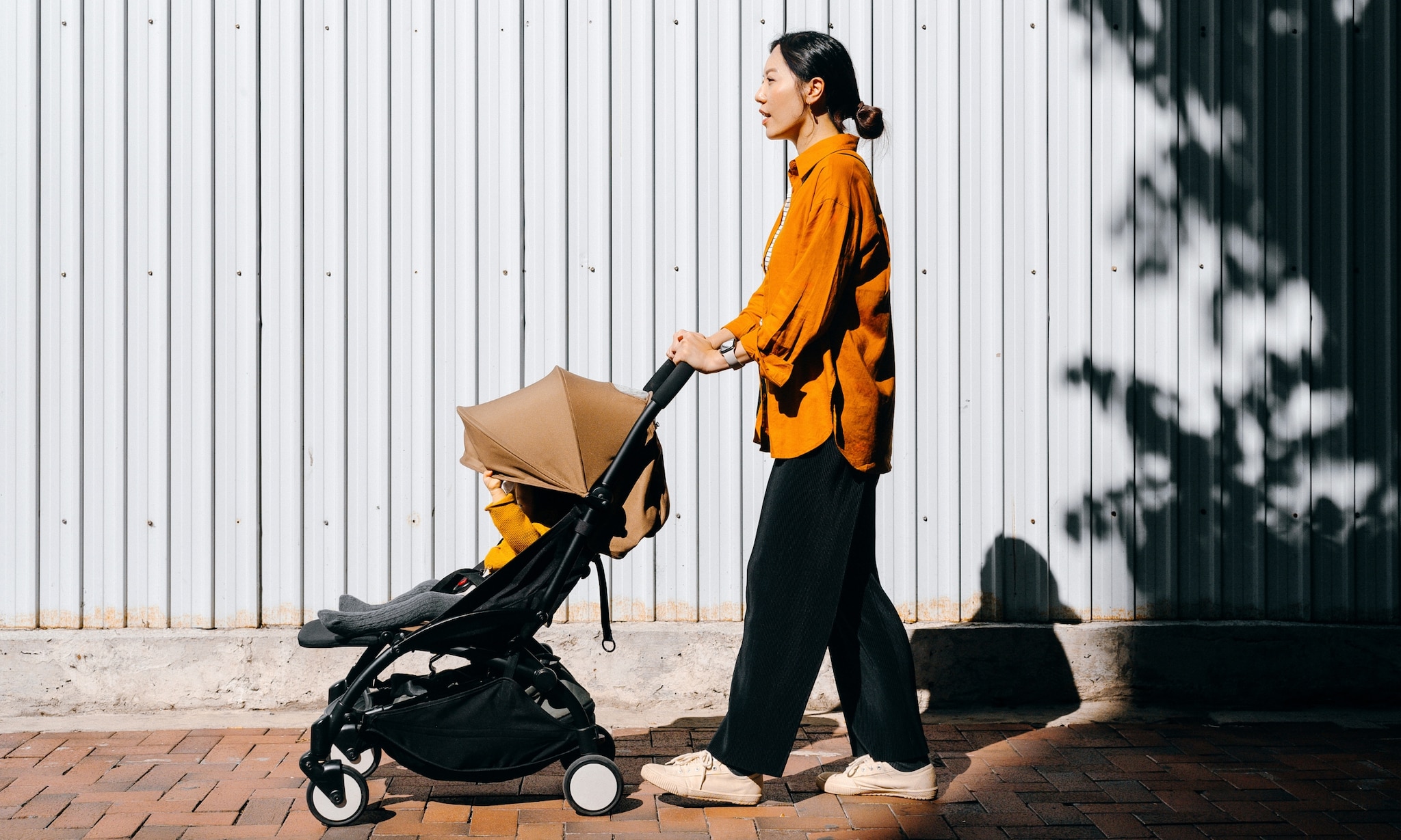 moeder met kind in compacte buggy voor in vliegtuig handbagage Getty Images