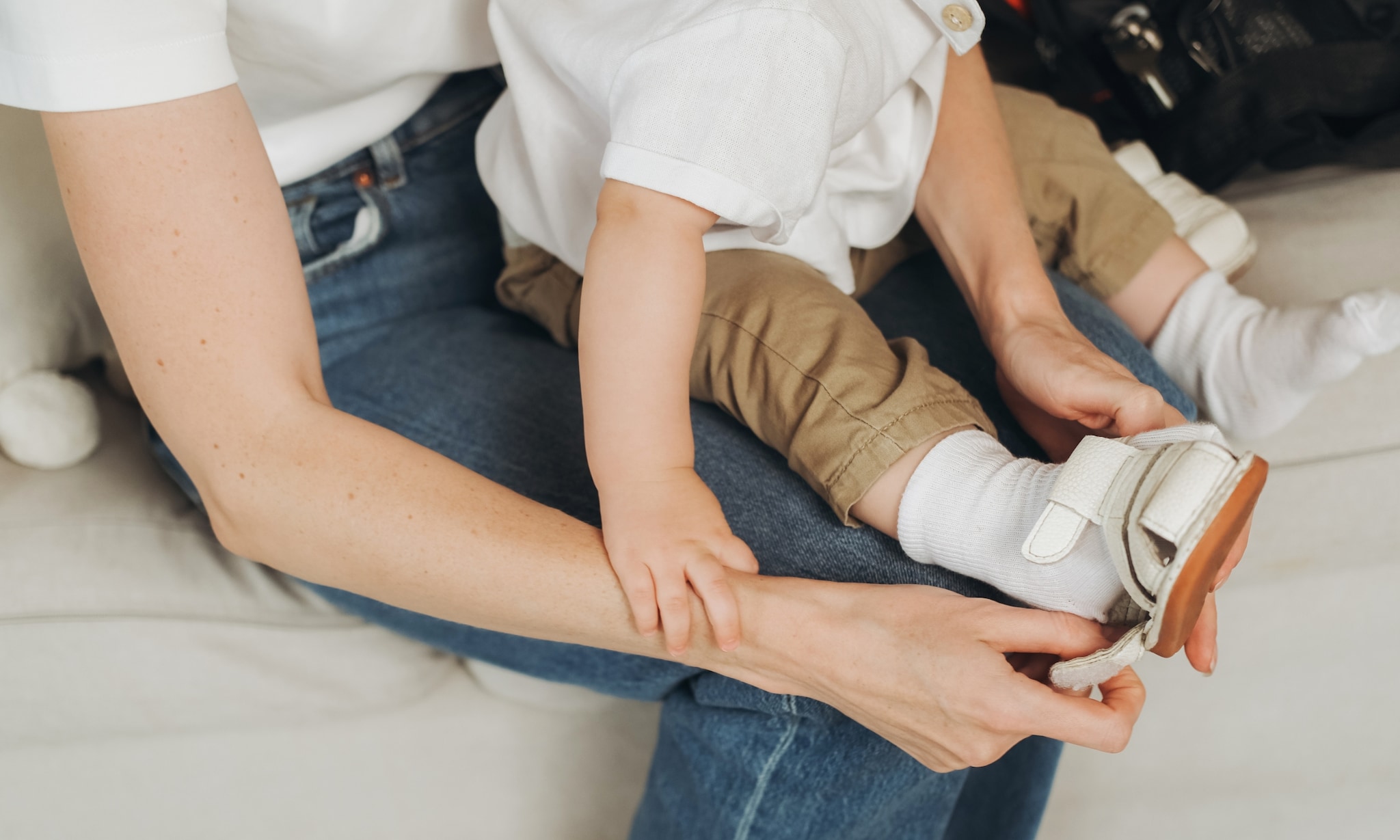moeder helpt baby met eerste loopschoenen voor de eerste stapjes Getty Images