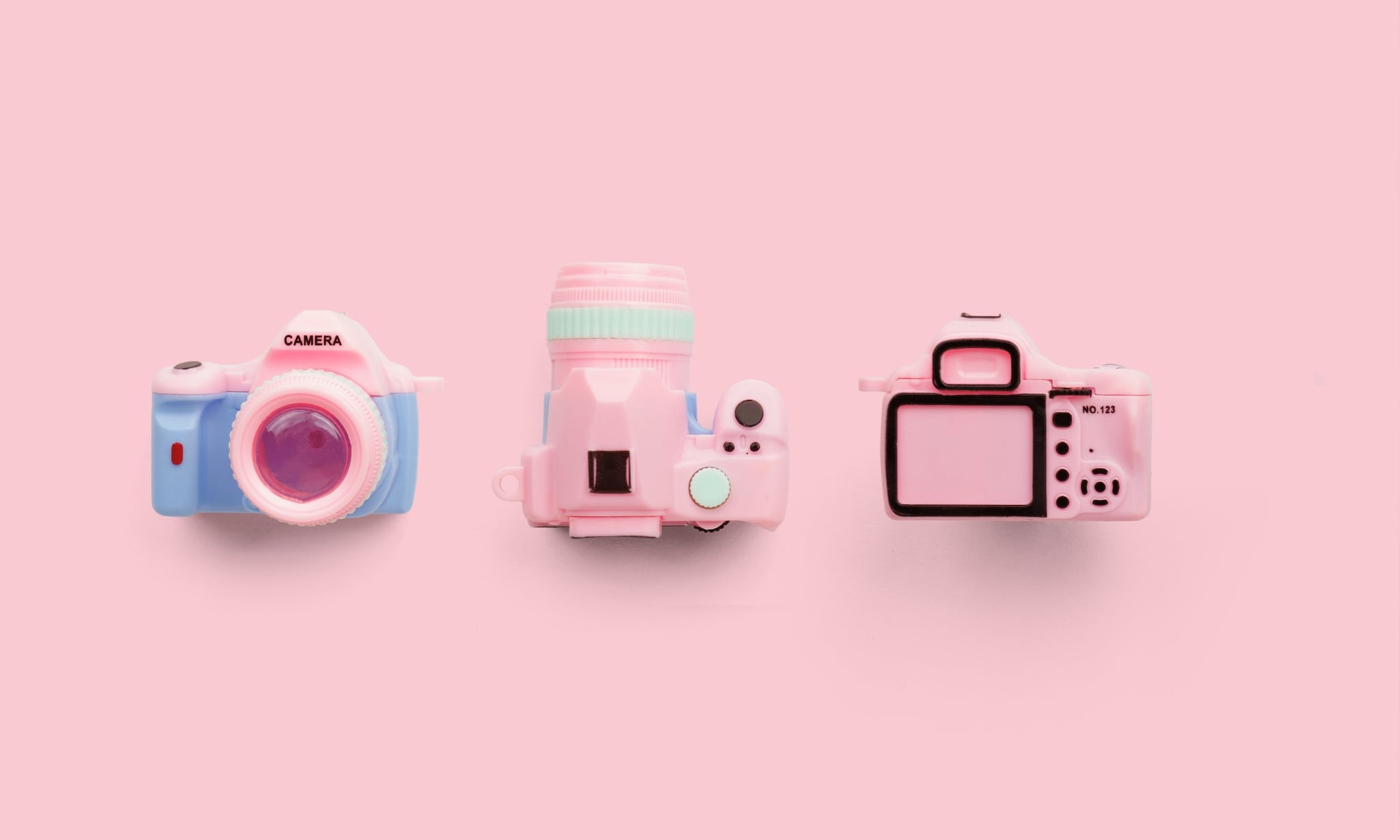 Drie roze camera’s met een roze achtergrond bij artikel over regels voor vlogfamilies. Getty Images