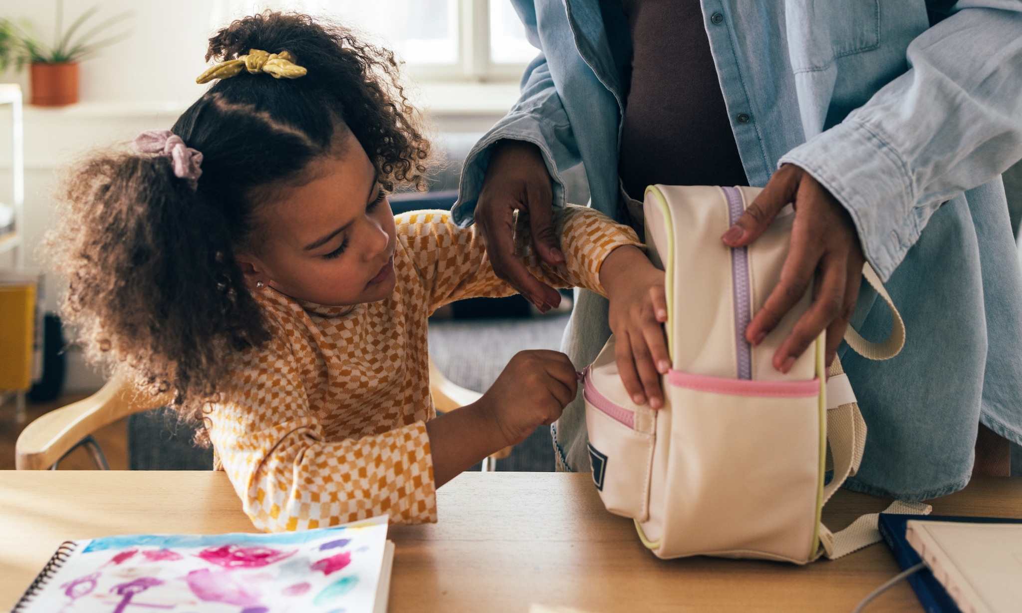 meisje pakt een van de leukste kinderrugzakken voor school in Getty Images