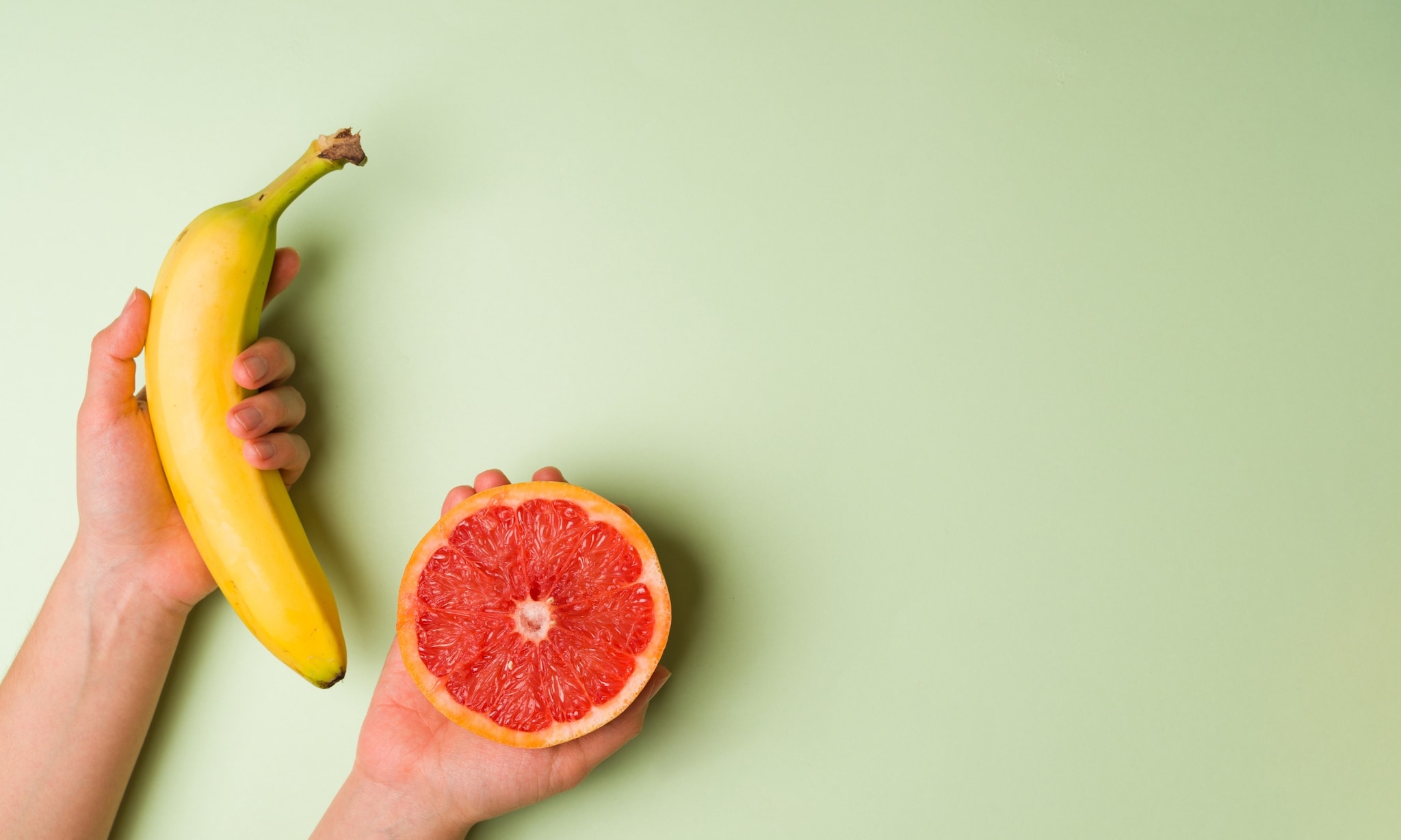 Banaan en grapefruit op groene achtergrond, bij rubiek Seksdagboek. Getty Images