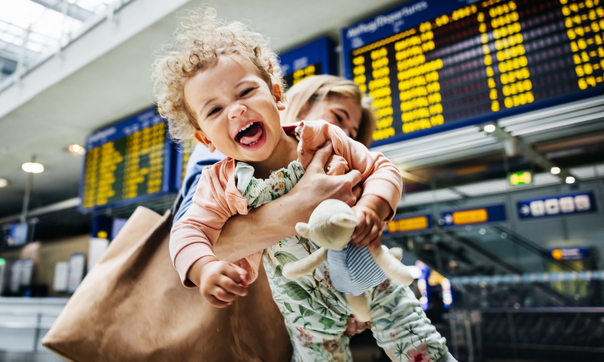 moeder en kind op vliegveld, gebruiken slimme gadgets voor reizen met kleine kinderen Getty Images