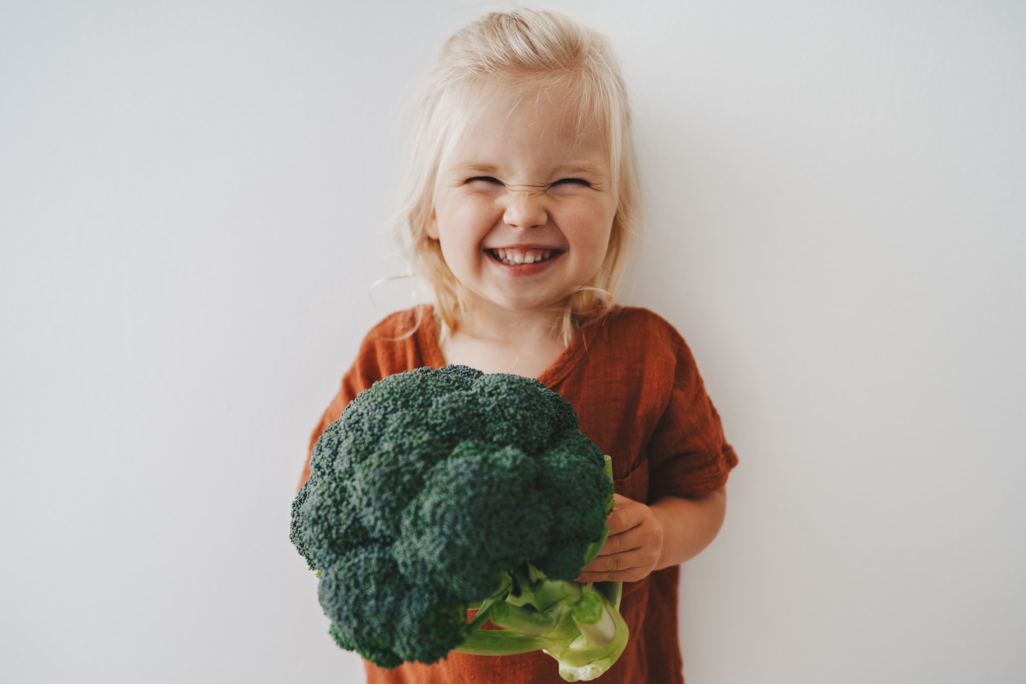 Child girl with broccoli healthy food vegan eating lifestyle organic vegetables plant based diet nutrition funny kid happy smiling Getty Images