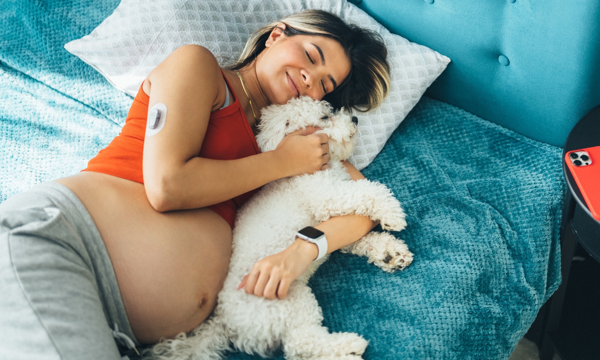 Zwangere vrouw knuffelt met haar hond Getty Images