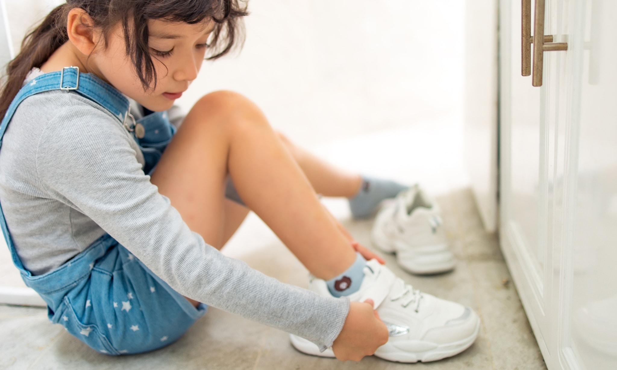 meisje trekt schoenen aan na advies podotherapeut om kinderschoenen niet tweedehands te kopen Getty Images