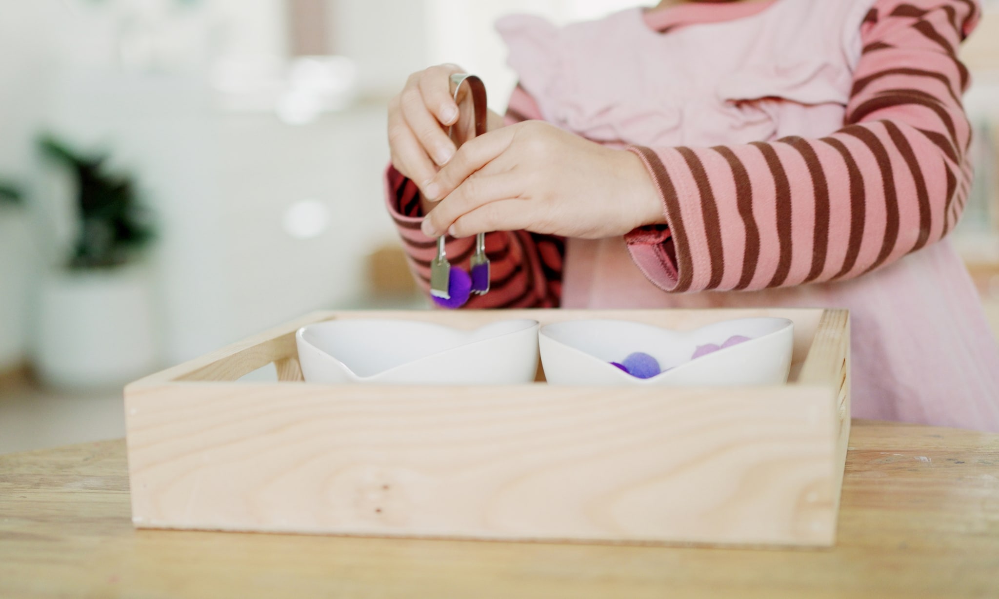 kind speelt met houten speelbak en sensorisch speelgoed Getty Images