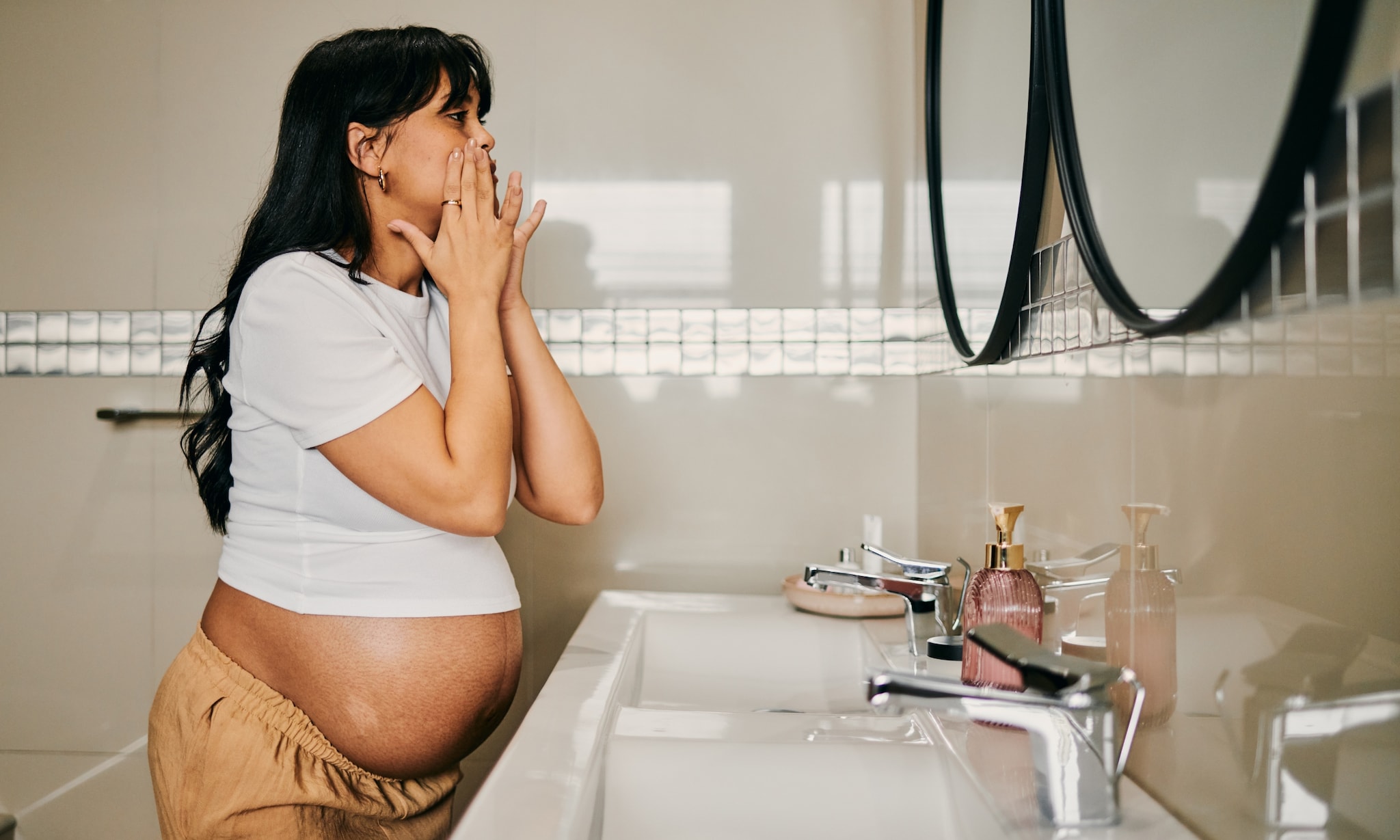 zwangere vrouw heeft droge huid en smeert gezicht in met creme Getty Images