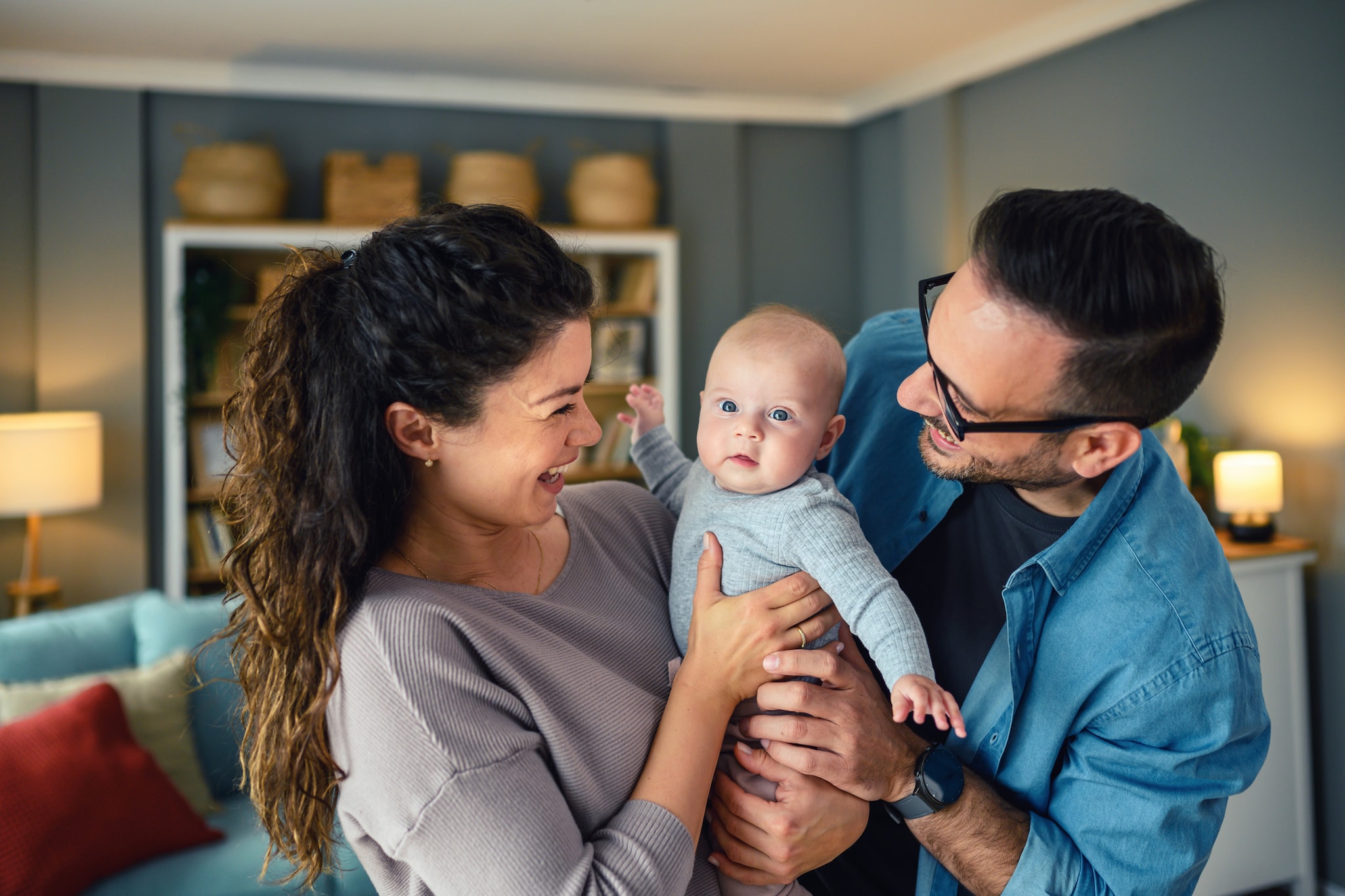 Happy young parents playing with their baby girl at home Getty Images