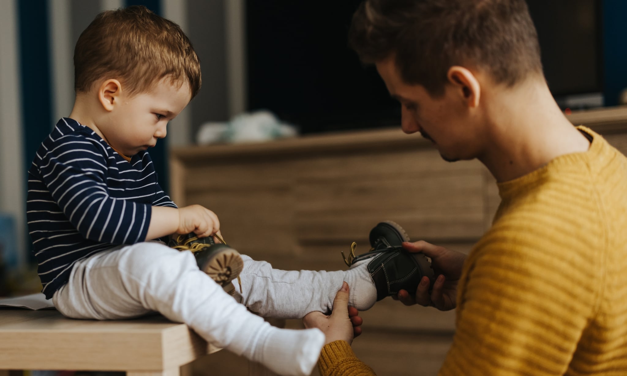 vader helpt kind met de eerste babyschoentjes Getty Images