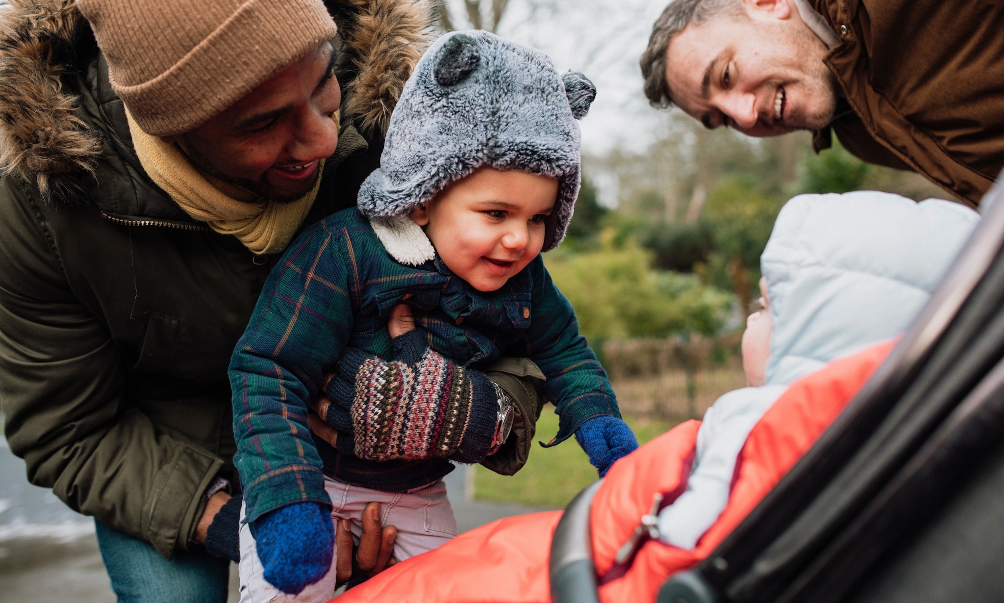 Vaders wandelen met hun zoons en gebruiken voetenzak voor kinderwagen buggy of autostoel Getty Images