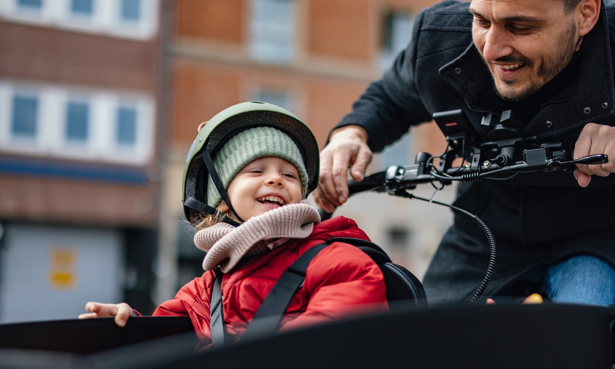 vader en zoon met elektrische bakfiets, als symbool voor nieuwe lovens explorer 2 bakfiets met stoelverwarming Getty Images