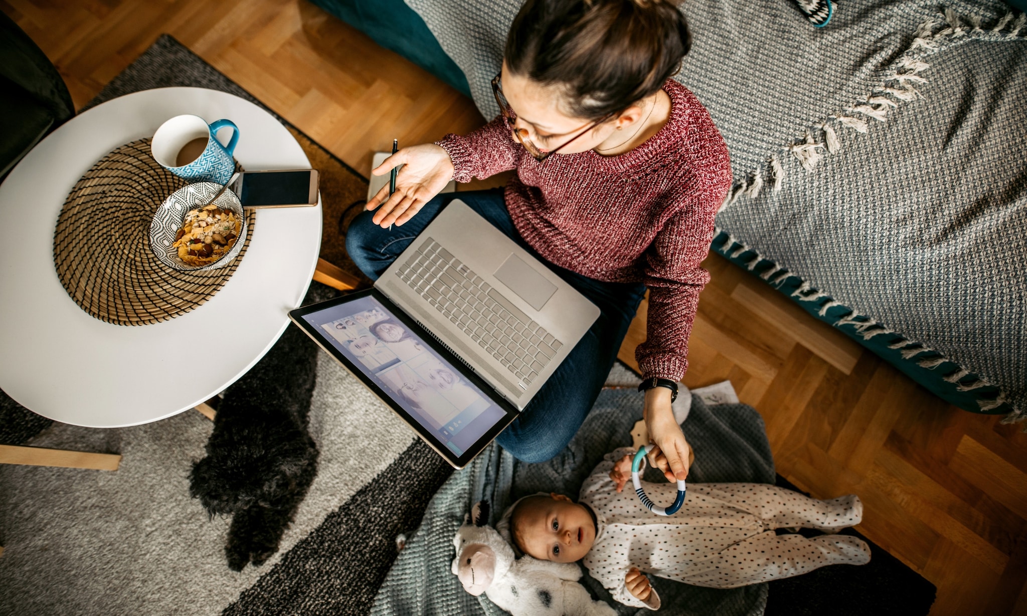 Moeder thuis aan het werk met baby. Getty Images
