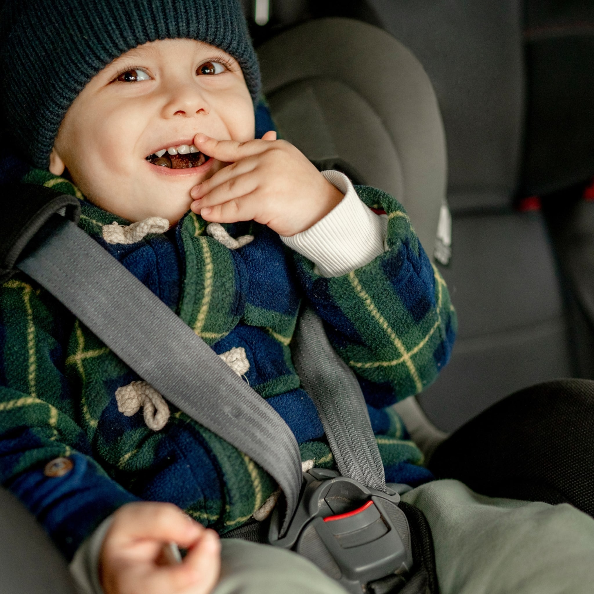 kind in autostoeltje winterjas uit
