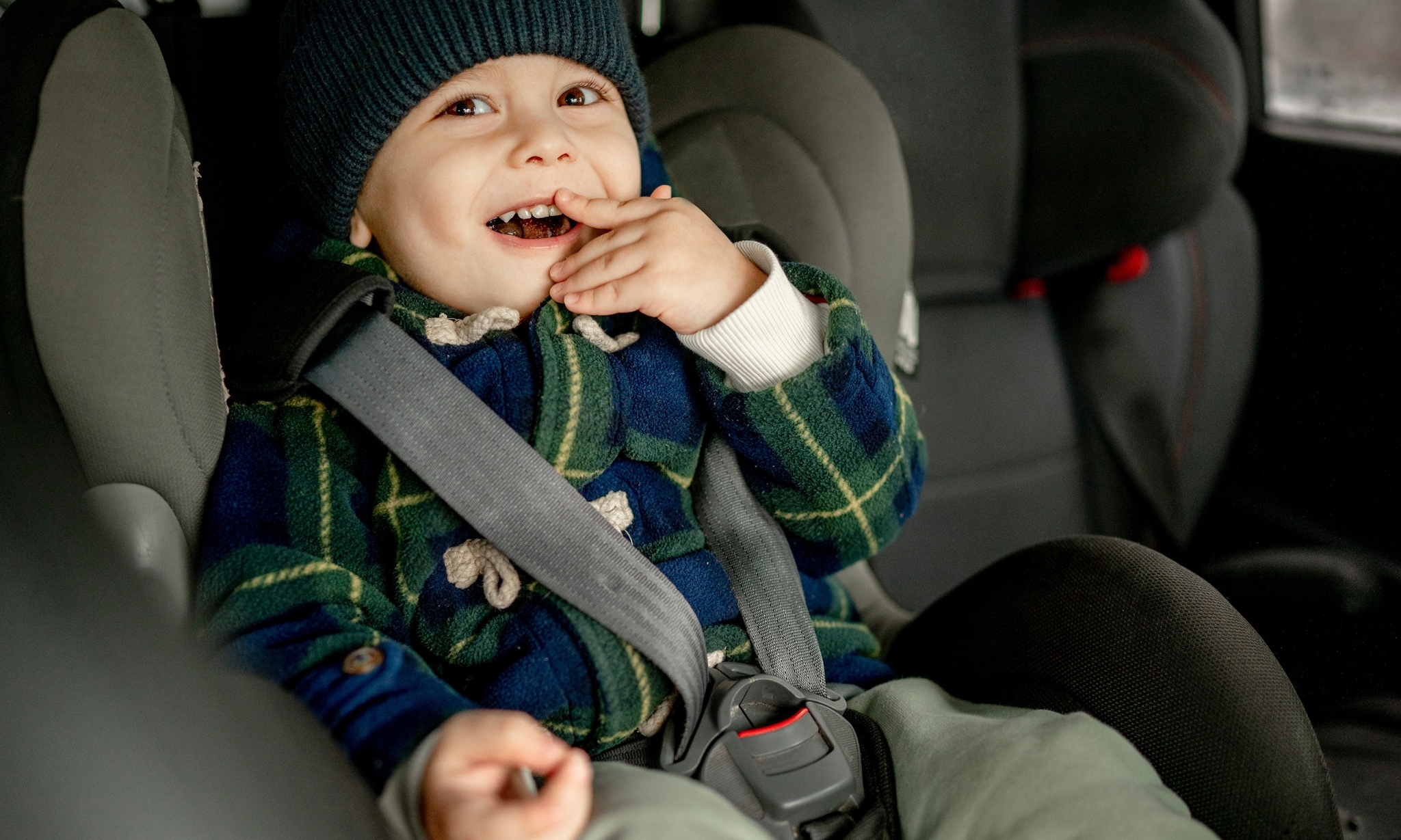 Kind in autostoel zonder winterjas aan. Getty Images
