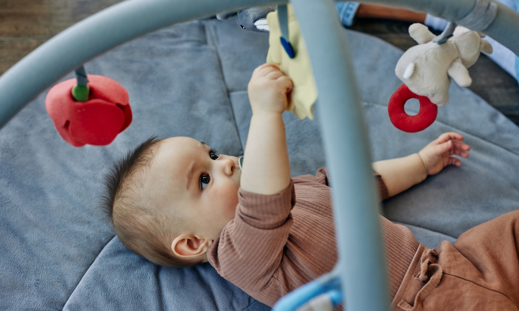 baby ligt onder babygym, dit zijn de leukste tips voor babyspeelgoed per leeftijdsfase Getty Images
