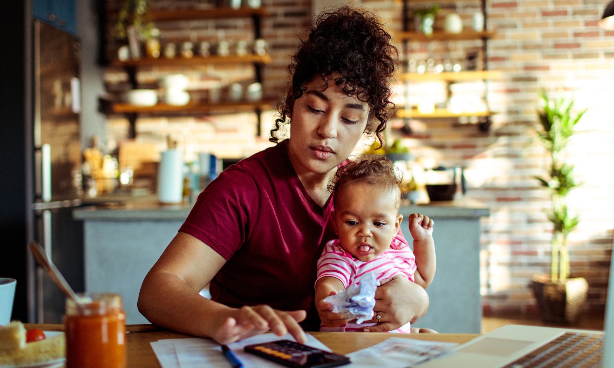 moeder zit met jong kind aan keukentafel en ze bekijkt de 10 beste black friday baby deals volgens ouders van nu Getty Images