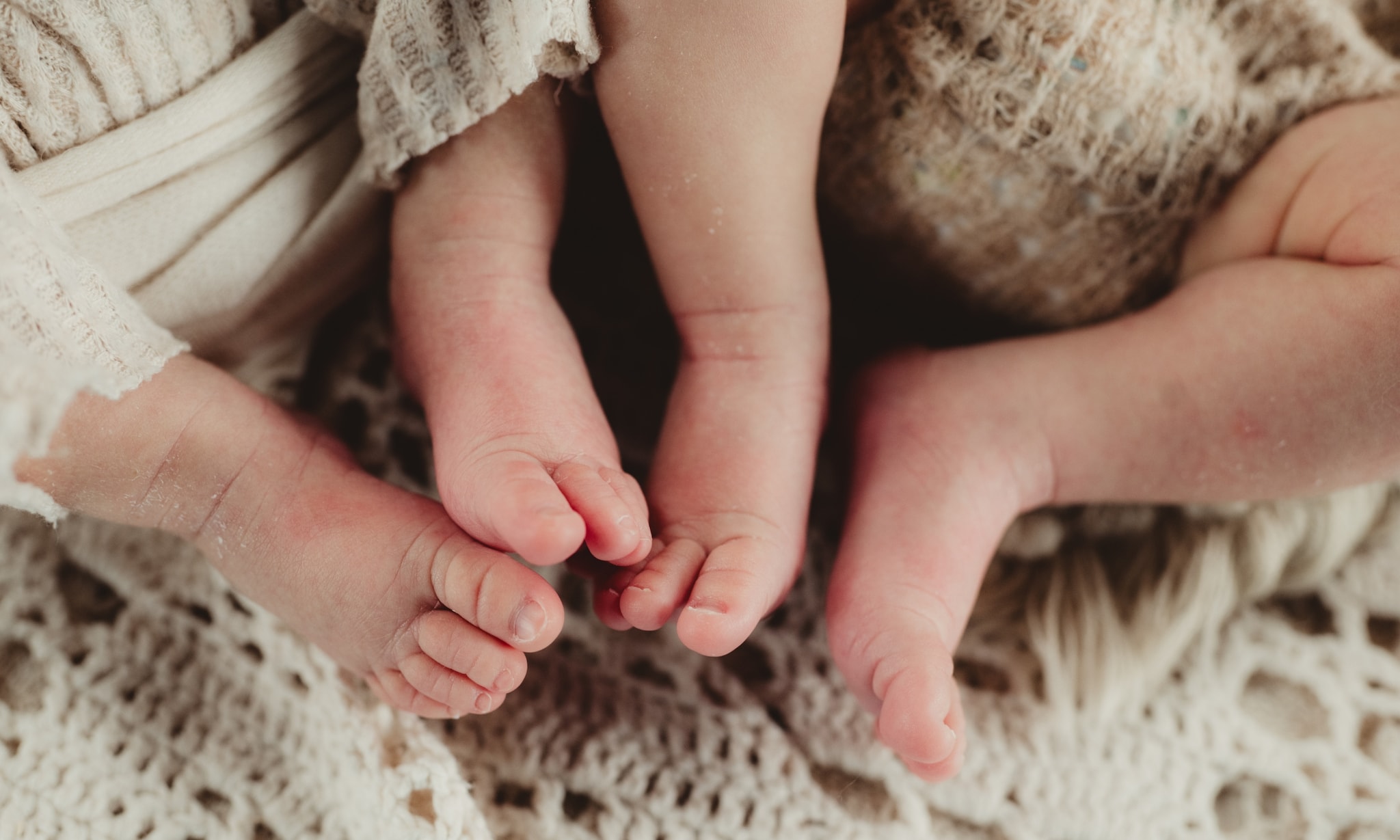 Benen en voeten van pasgeboren tweeling. Getty Images