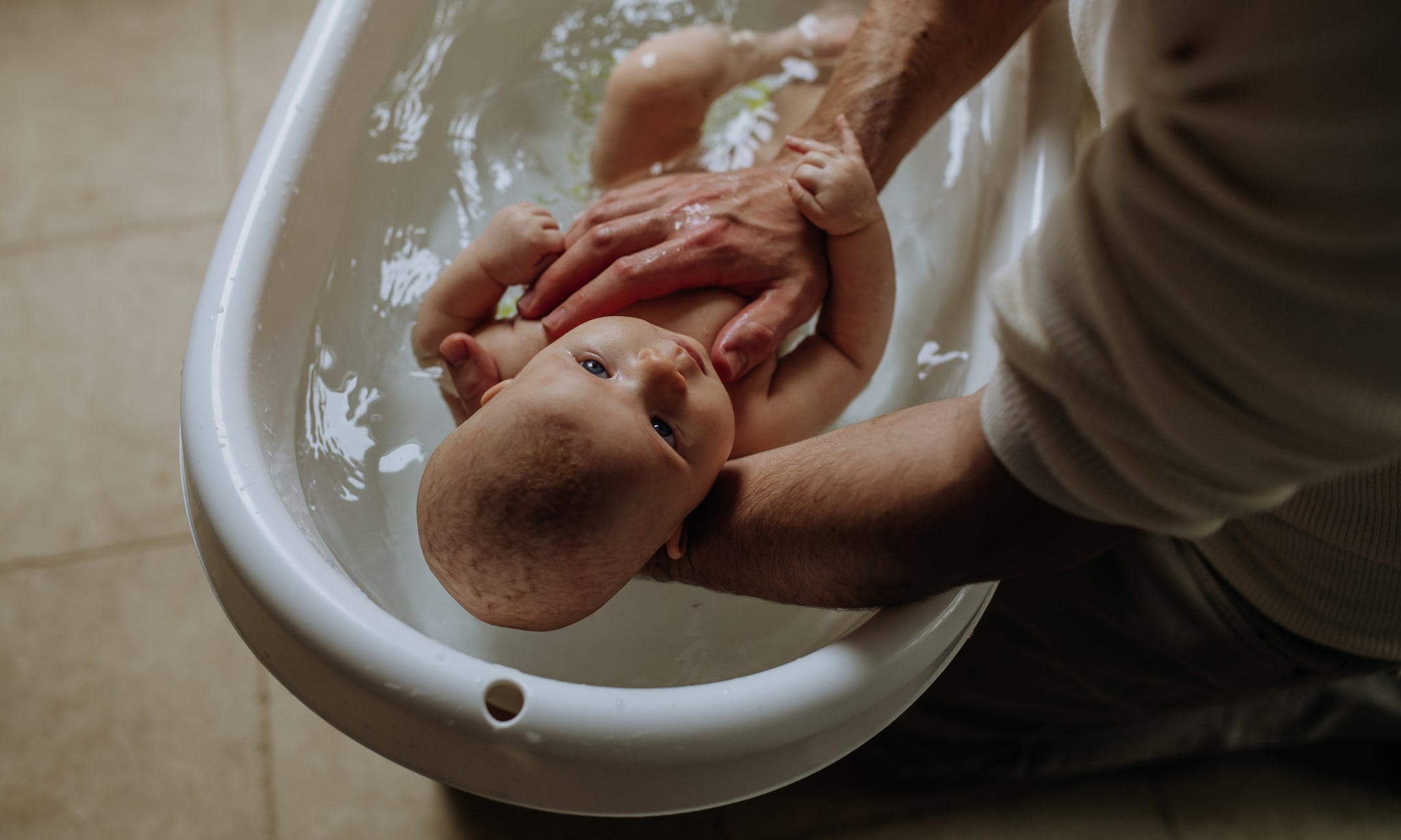 vader wast baby in babybadje, hier moet je op letten als je er een aanschaft Getty Images