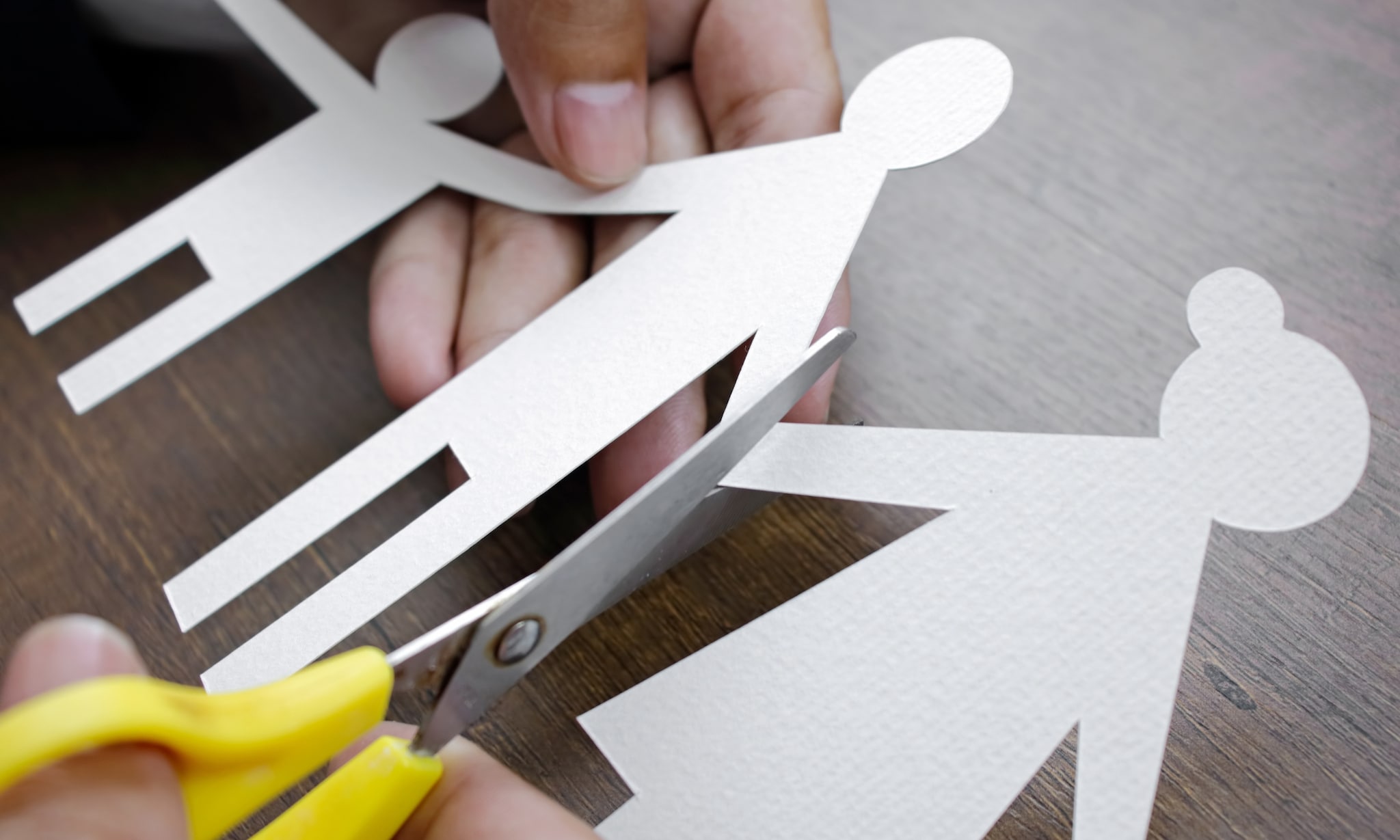 Papieren ouders en kind met schaar als symbool voor scheiding. Getty Images