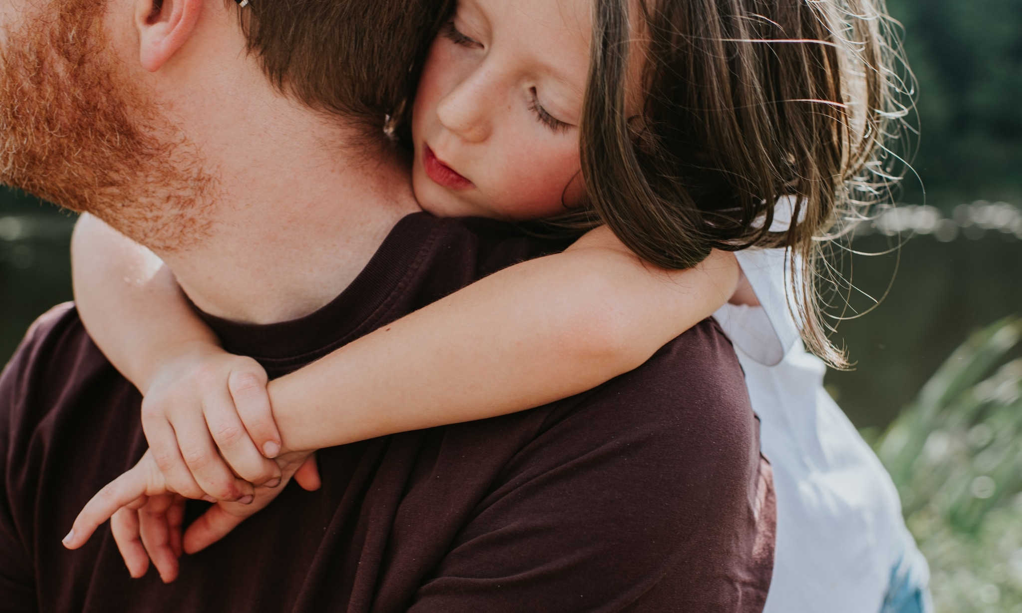 Meisje omhelst haar vader, bij onderzoek over alleenstaand ouderschap en gezondheid. Getty Images