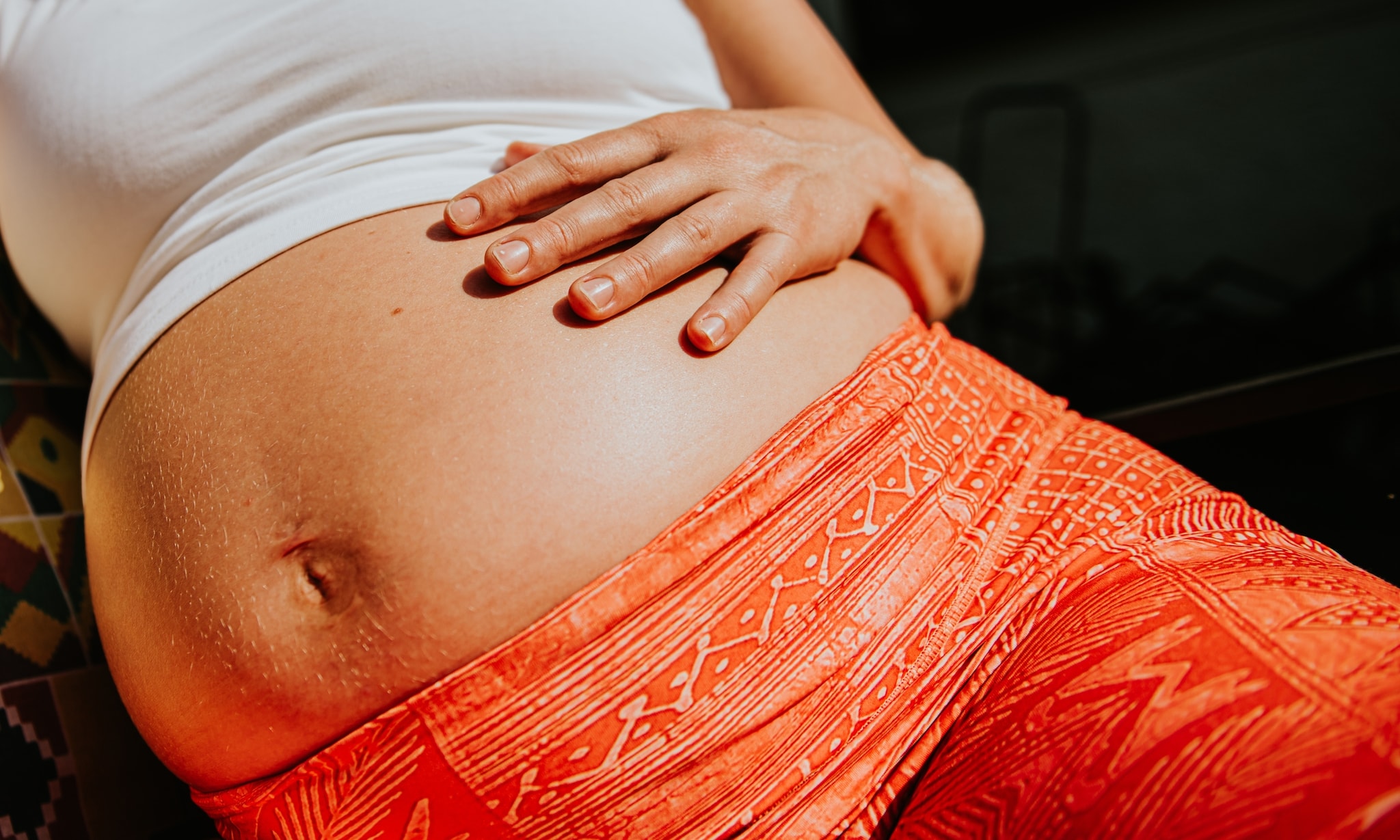 Hoogzwangere vrouw vangt weeen op voor bevalling. Getty Images