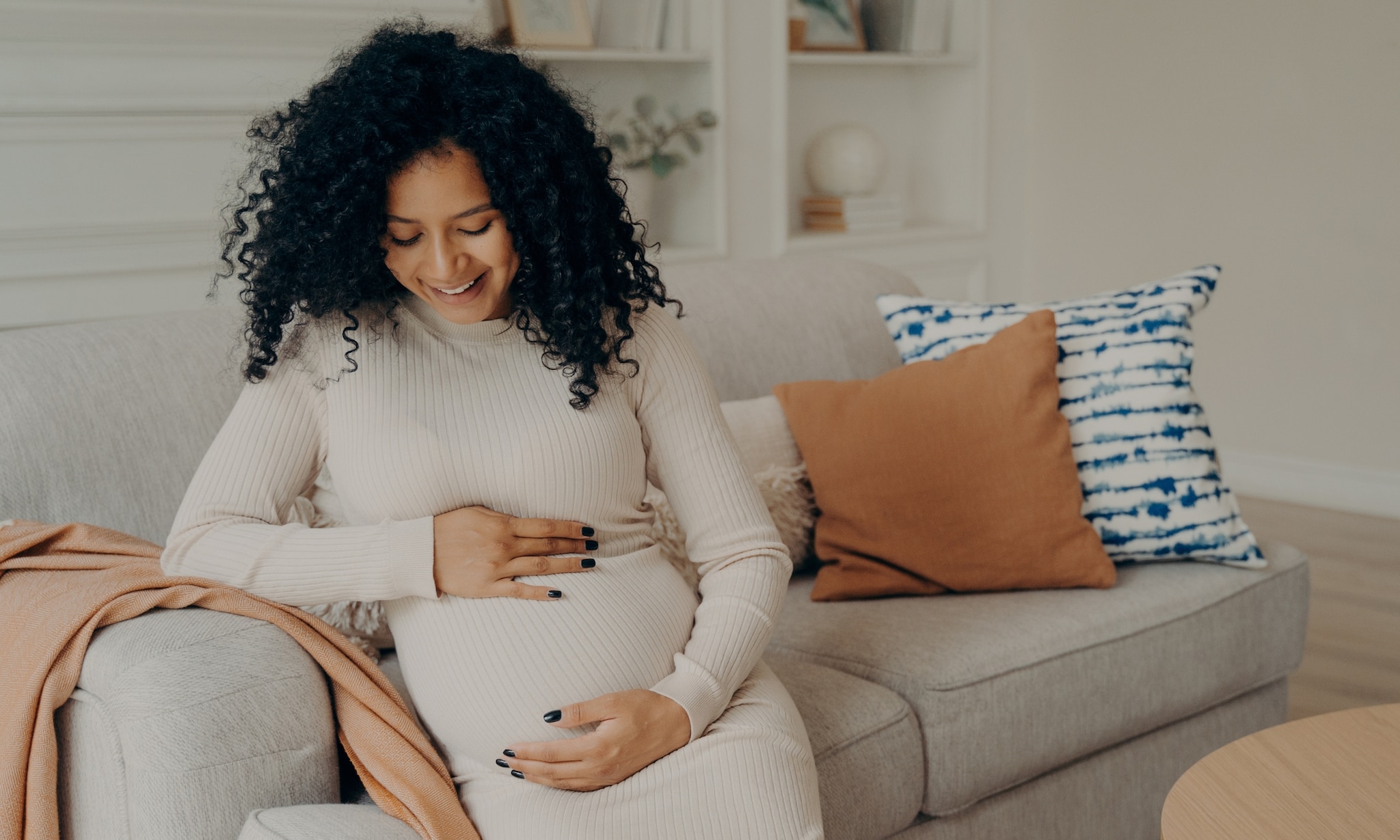 vrouw draagt mooie zwangerschapskleding voor najaar en winter die nu in de sale is Getty Images