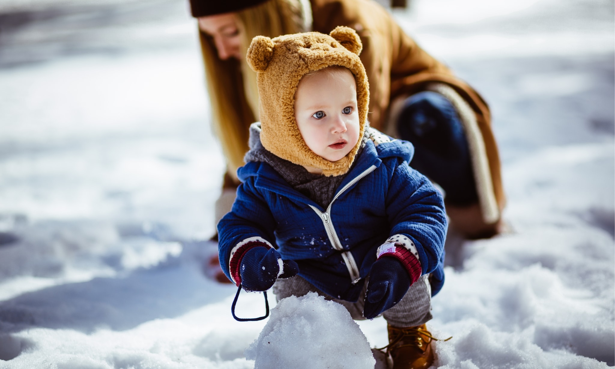 peuter speelt met moeder in sneeuw en draagt balaclava voor kinderen, dit is waarom het zo'n goed alternatief is voor een sjaal en muts Getty Images