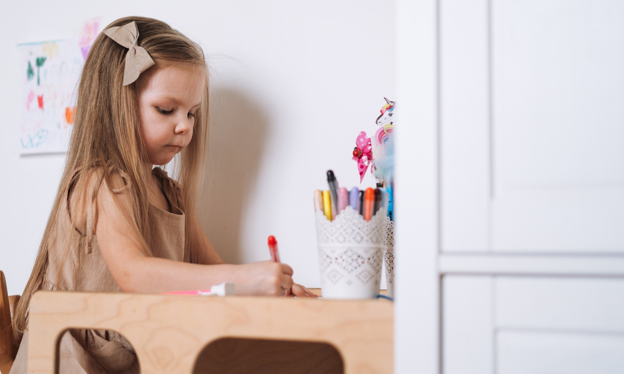 meisje zit te tekenen aan tafeltje en leertoren in één van Action Getty Images
