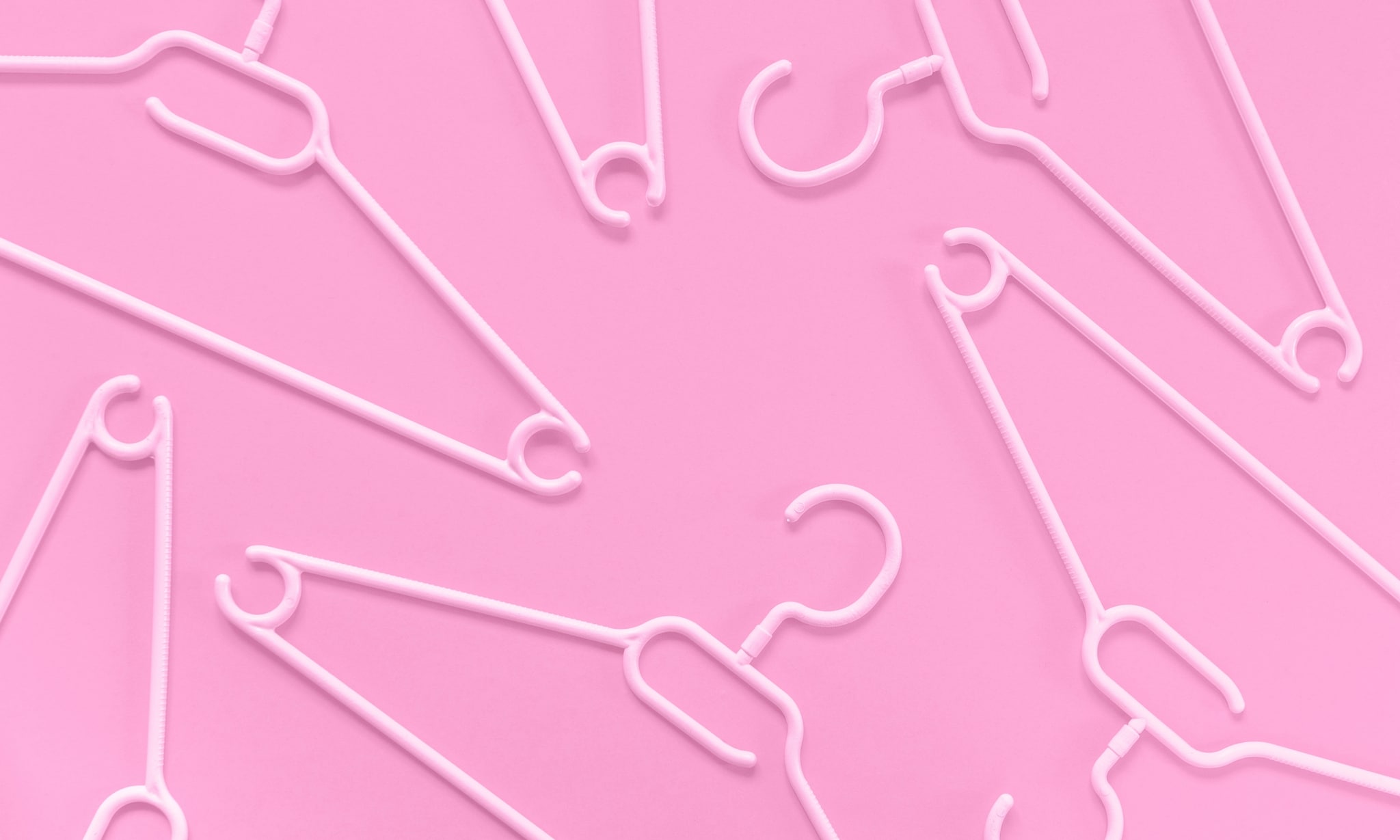 plastic kledinghangers voor roze achtergrond, voor artikel over alternatieven voor synthetische plastic kinderkleding