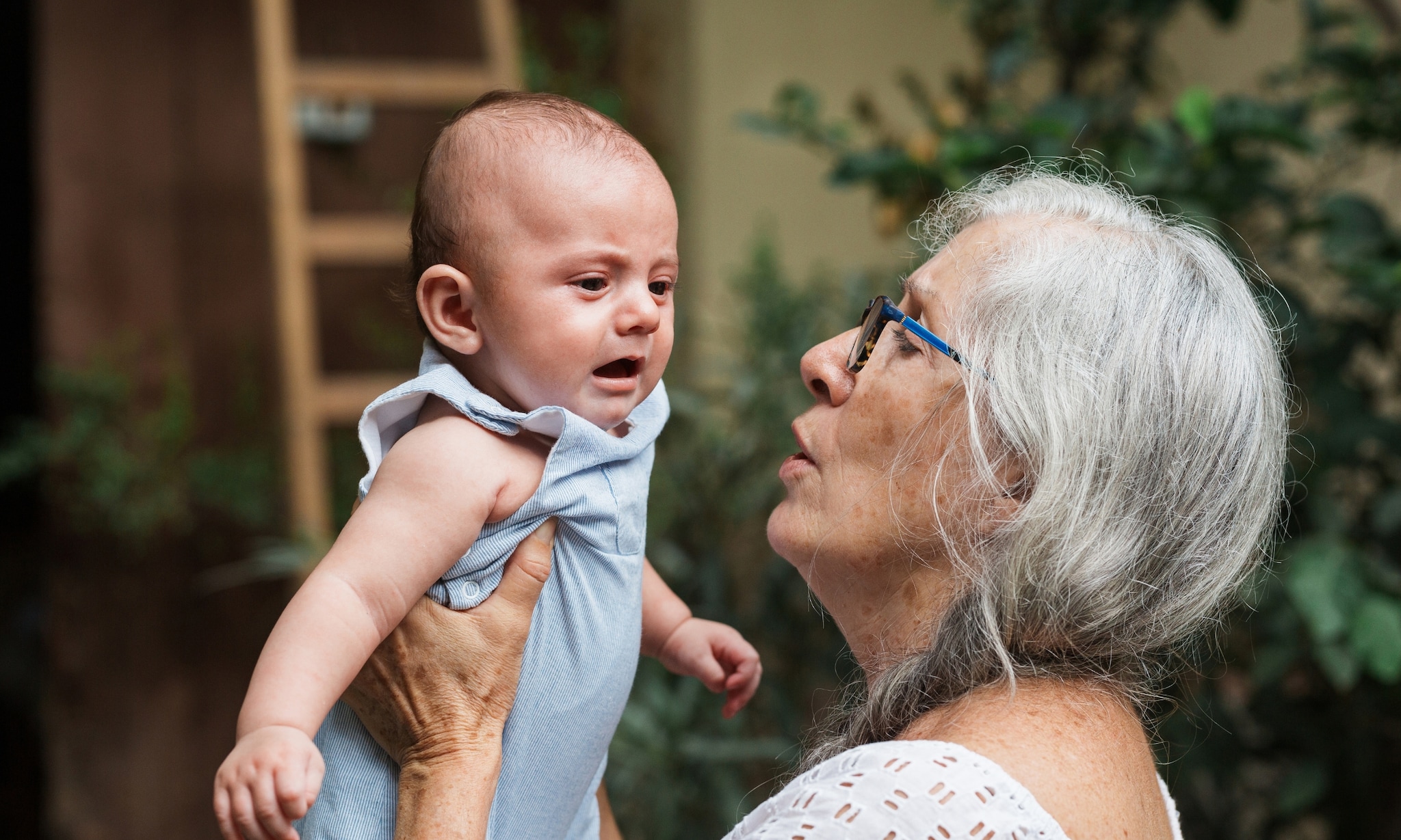 Oma houdt baby vast, bij artikel over oppassen en gezondheid opa en oma. Getty Images