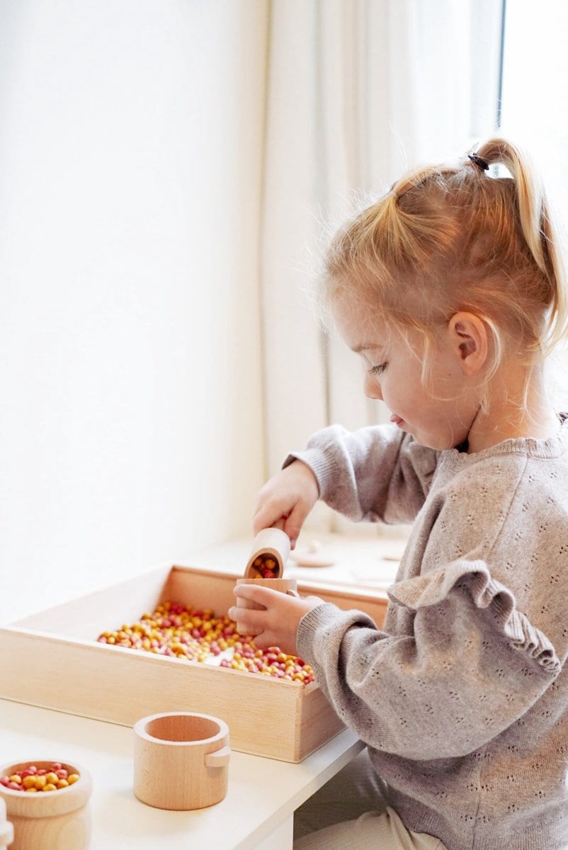 meisje speelt met houten speelbak van wizzimo Wizzimo