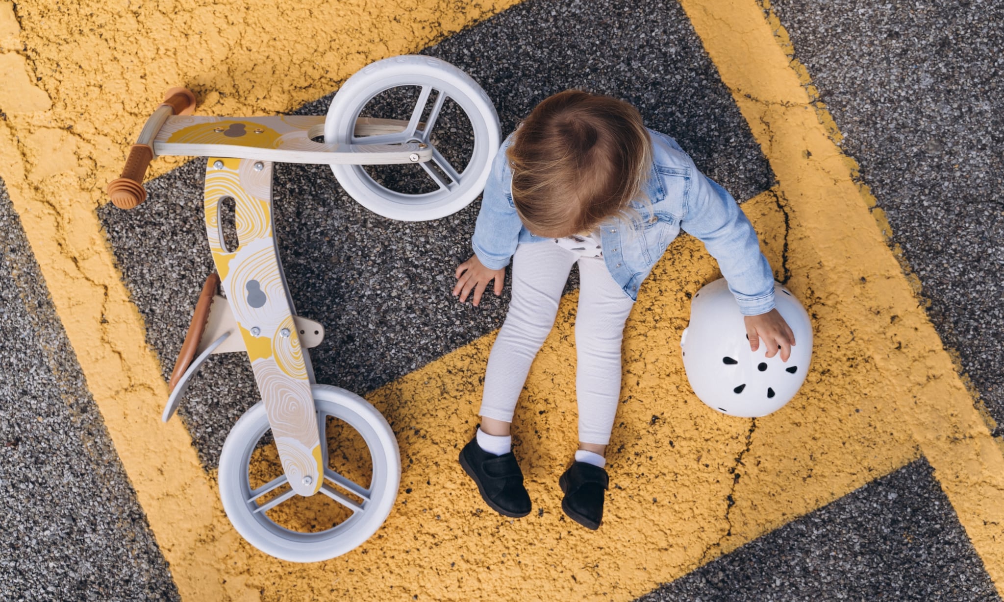 kind zit naast loopfiets met helm ernaast, dit zijn de beste loopfietsen per leeftijd Getty Images