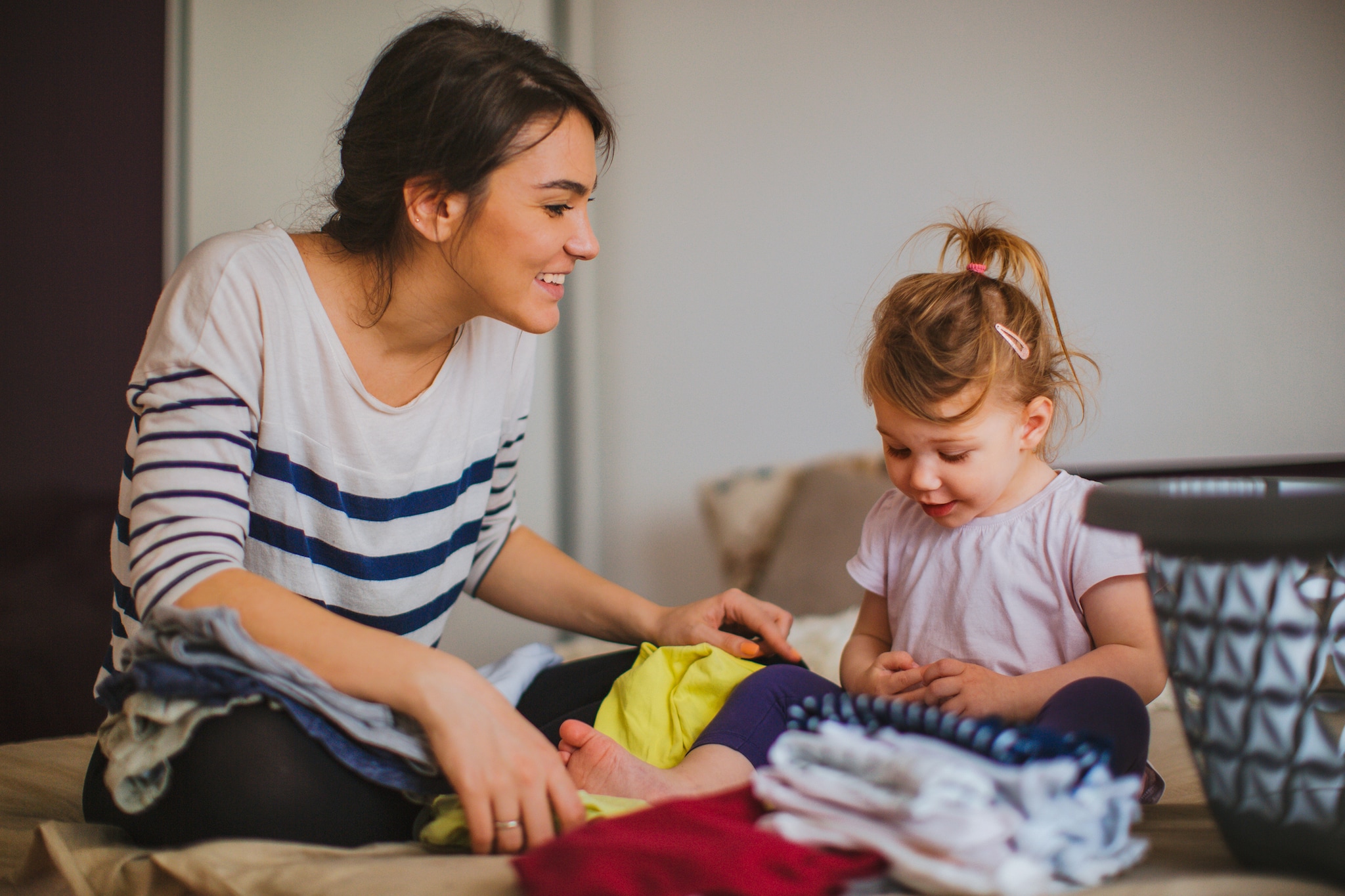 Mother and her daughter folding laundry together Getty Images