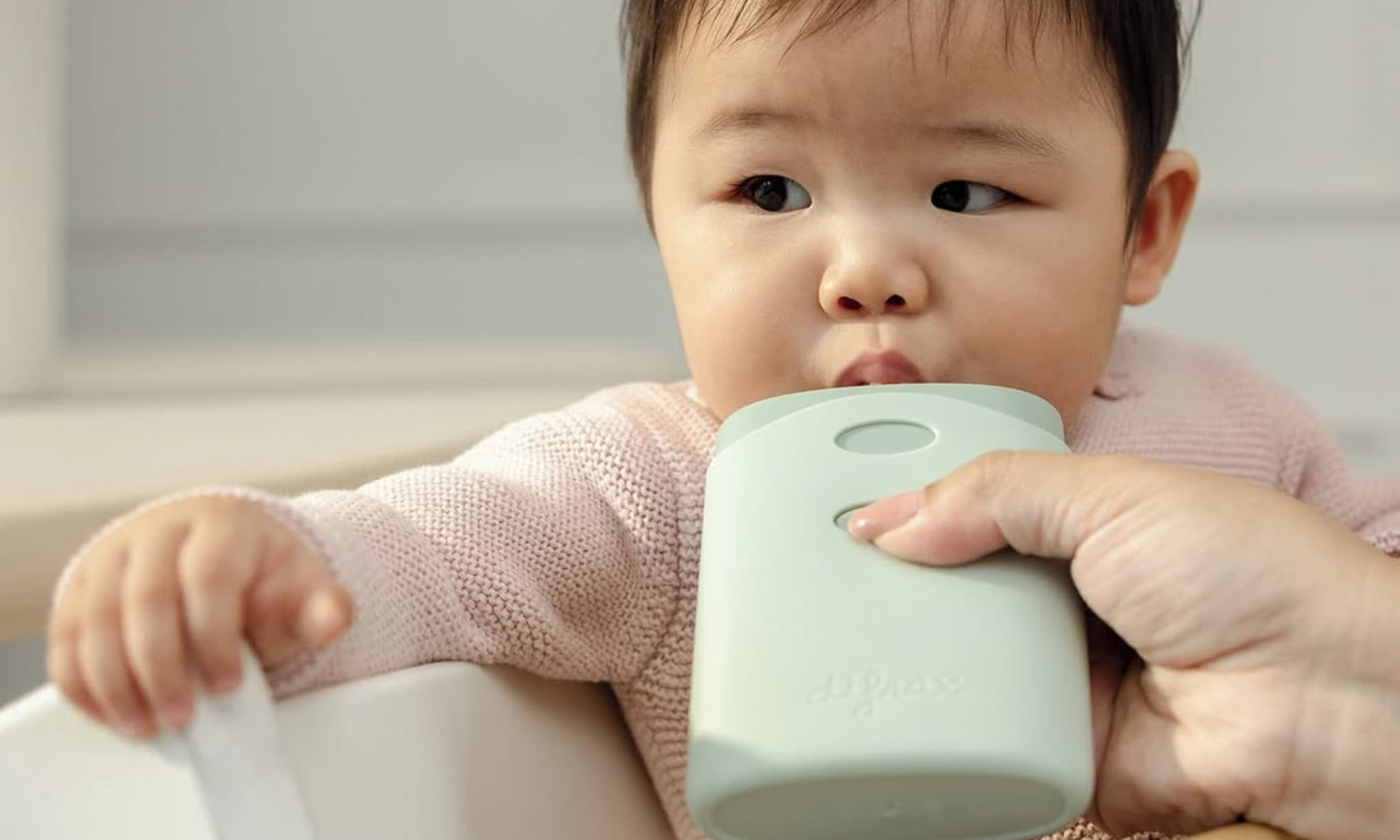 kind eet fruithapje met behulp van anti-knoei knijpzakjeshouder van Difrax Difrax